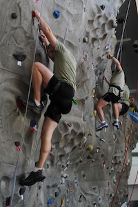 Members of the Monster Mash team "Hammer Time" climb the rock wall at the Outdoor Recreation Center on Joint Base Charleston - Air Base, May 19.  The Monster Mash event is 3.1 miles long and includes six challenging obstacles including a wall climb, truck push, mule pull, litter carry, jersey tug, and tire flip.  The Monster Mash was hosted by the 437th Operations Support Squadron.  (U.S. Air Force photo/ Staff Sgt. Nicole Mickle 