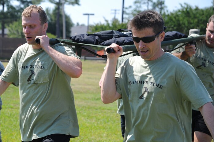 Maj. Timothy Huxel and Maj. Eric Skipper, along with their "Hammer Time" teammates  carry  a 100 pound litter on Joint Base Charleston - Air Base, May 19, during the Monster Mash, a 3.1 mile long contest that included a wall climb, truck push, mule pull, litter carry, jersey tug, and tire flip. The Monster Mash was hosted by the 437th Operations Support Squadron. Teams of four competed for the best time. Major Huxel and Major Sikpper are from the 437th Operations Group.  (U.S. Air Force photo/ Staff Sgt. Nicole Mickle)