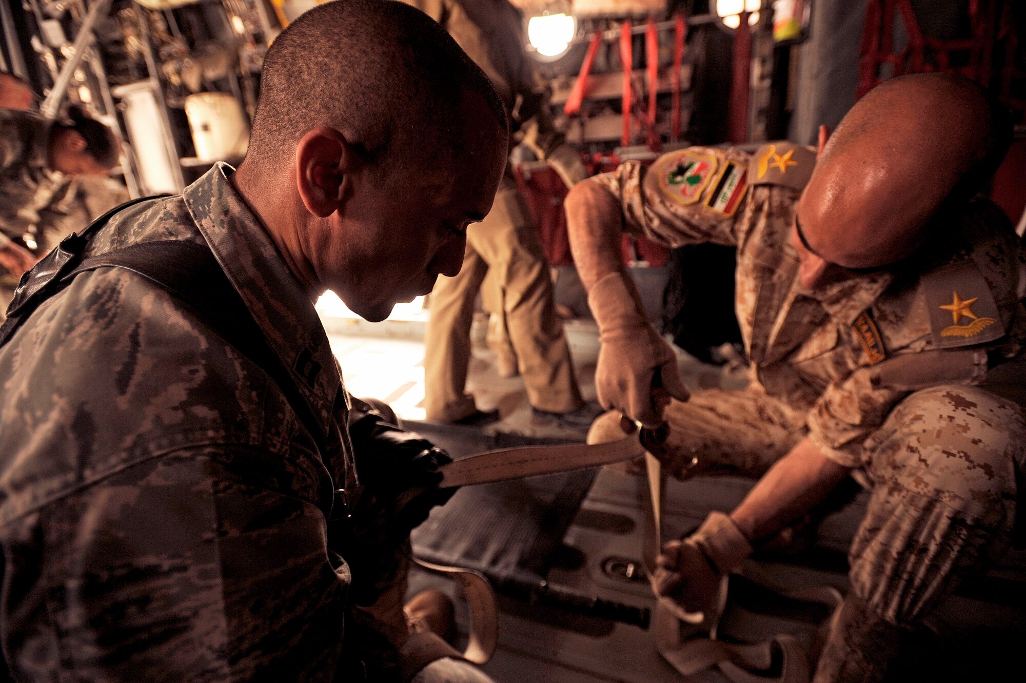 NEW AL-MUTHANA AIR BASE, Iraq – U.S. Air Force Capt. Reggie Brown, left, 332nd Expeditionary Medical Group critical care nurse, teaches his Iraqi counterparts how to secure a litter to the floor of a C-130 Hercules May 19. Six Iraqi medics learned the basics of aeromedical evacuation over two days with U.S. Air Force and Army advisors from Sather Air Base, Joint Base Balad and Camp Taji. The medics also learned about medical evacuation capabilities and safety considerations for UH-60 Blackhawk, Mi-171 Hip and UH-1 Huey helicopters. Captain Brown is deployed from Eglin Air Force Base, Fla., and hails from Long Island, N.Y. (U.S. Air Force/Tech. Sgt. Jason Lake)