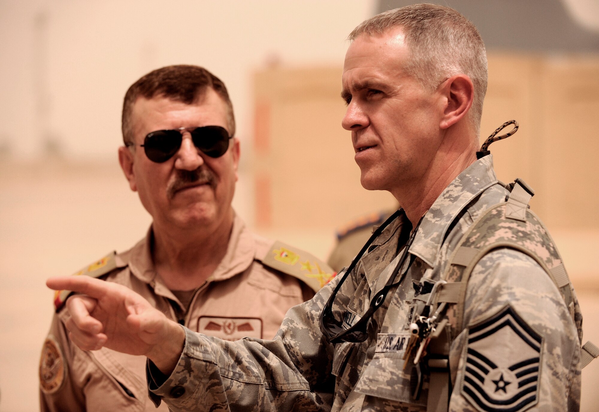 NEW AL-MUTHANA AIR BASE, Iraq -- Senior Master Sgt. Marvin Howell, 332nd Expeditionary Medical Operations Squadron superintendent, speaks with Iraqi air force chief of staff, Lt. Gen. Anwar Ahmed, as Iraqi medics practice litter carrying commands May 19. Six Iraqi air force medics received two days of joint aeromedical evacuation training with U.S. Air Force and Army advisors. Sergeant Howell is deployed from Lackland Air Force, Texas, and calls Suffolk, Va., home. (U.S. Air Force/Tech. Sgt. Jason Lake)