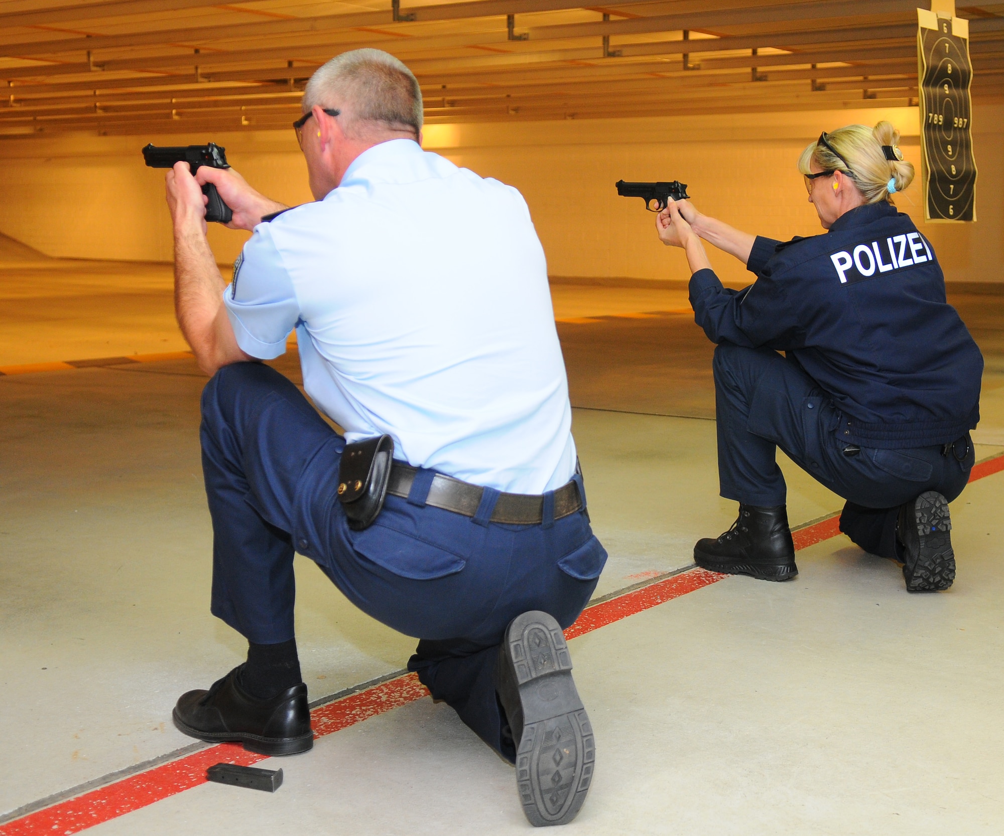 SPANGDAHLEM AIR BASE, Germany – German Police Sgts. Stefan Bartzen and Monika Rice-Mueller take aim from the kneeling position during the firing range event of the 52nd Security Forces Squadron Decathlon here May 17. The 52nd SFS Decathlon consisted of five teams competing in 10 separate events. (U.S. Air Force photo/Airman 1st Class Dillon Davis)
