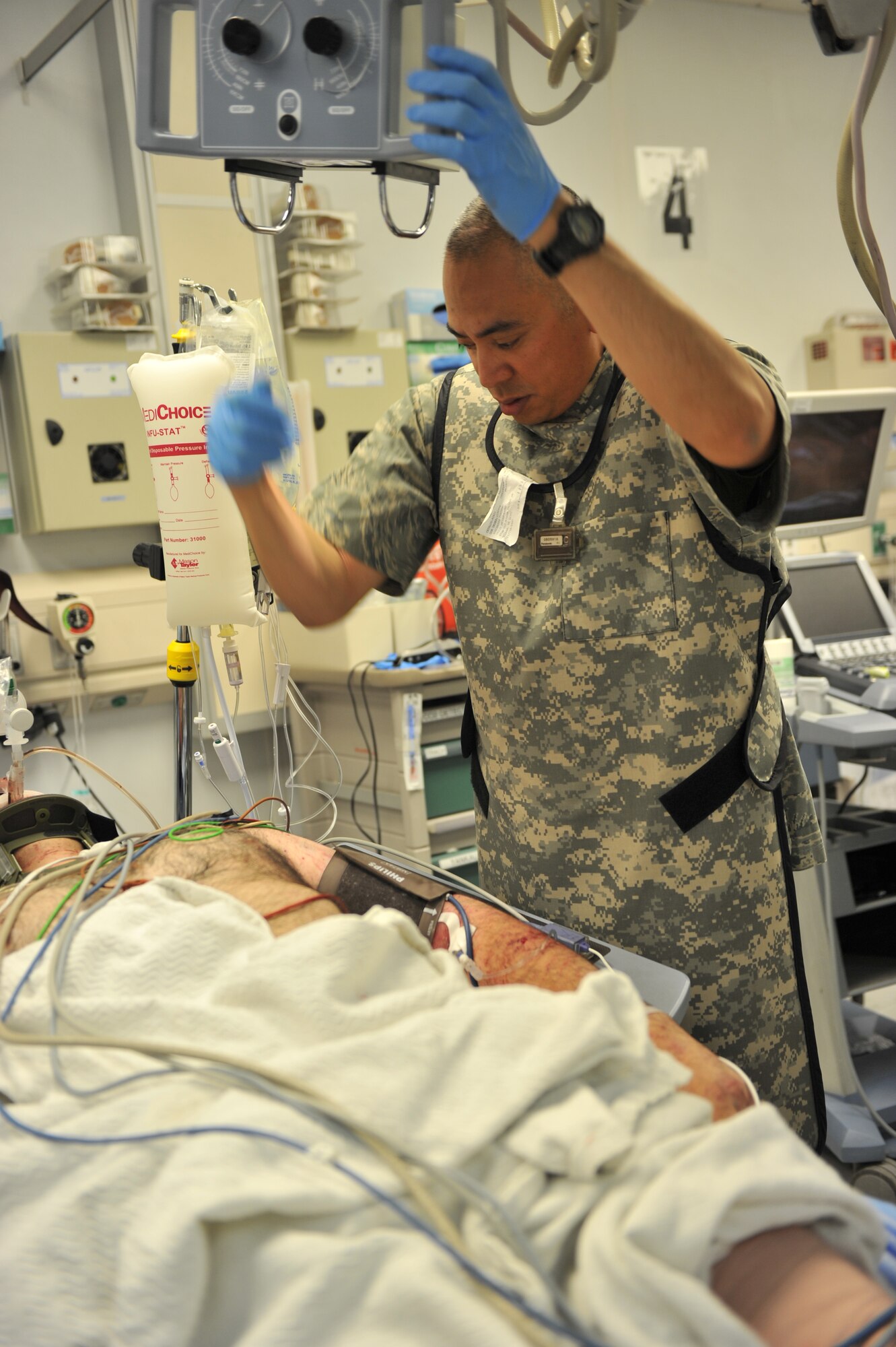 Tech. Sgt. Reginald Gesmundo an x-ray technican deployed to the Craig Joint Theater Hospital, Bagram Airfield, Afghanistan examines a patient's arm prior to administering an x-ray to look for factures.  Each day young Americans and Afghans enter into the facility's double-doors and begin what will be the toughest period of their lives. (U.S. Air Force photo by Senior Airman Sheila deVera)