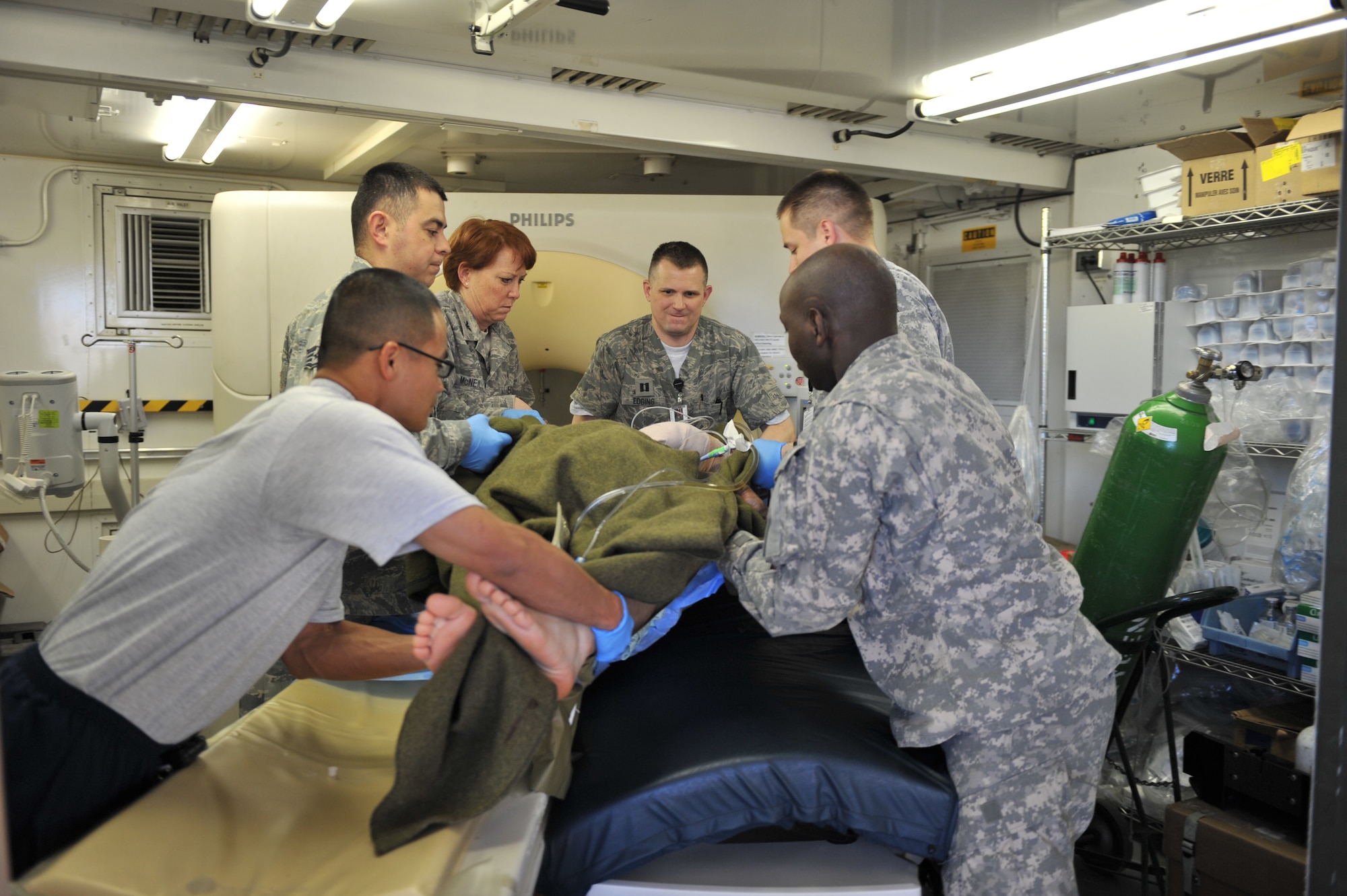 Members of the medical staff assist moving a patient from a computerized axial tomography scan at the Craig Joint Theater Hospital staff, Bagram Airfield, Afghanistan. Each day young Americans and Afghans enter into the facility's double-doors and begin what will be the toughest period of their lives. (U.S. Air Force photo by Senior Airman Sheila deVera) 