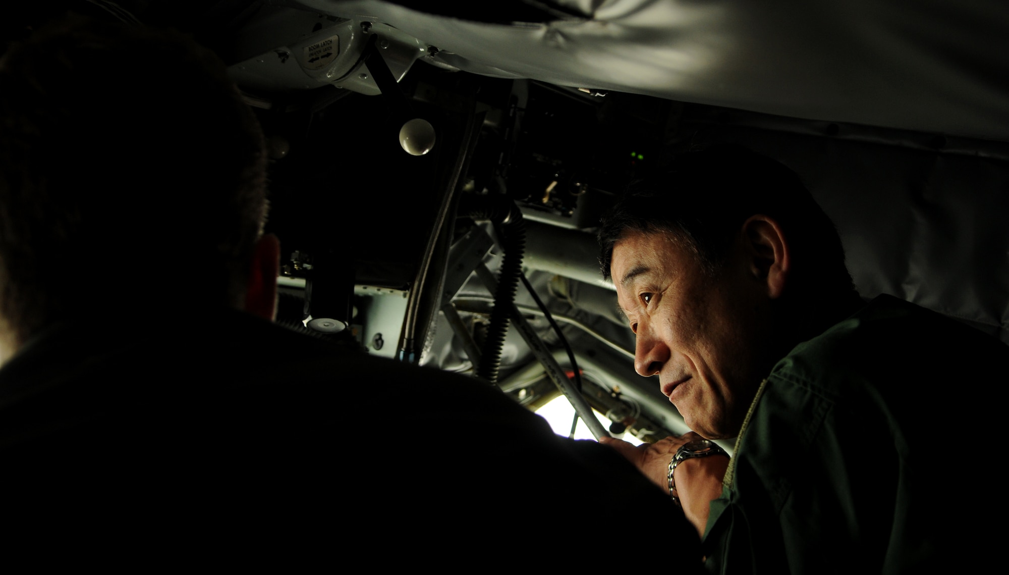 Master Sgt. Mike Webster, an in-flight refueling technician with the 909th Air Refueling Squadron, shows  Lt. Gen. Tsugio Ishino, Central Air Defense Force commander for the Japan Air Self Defense Force, how to operate a refueling boom aboard a KC-135 Stratotanker aircraft at Kadena Air Base, May 24. The orientation flight allowed Lt. Gen. Ishino to observe Japanese F-15J pilots' air refueling training. It also familiarized the General with the U.S. Air Force tanker capabilities during normal training operations. (U.S. Air Force photo/Airman 1st Class Jarvie Z. Wallace)