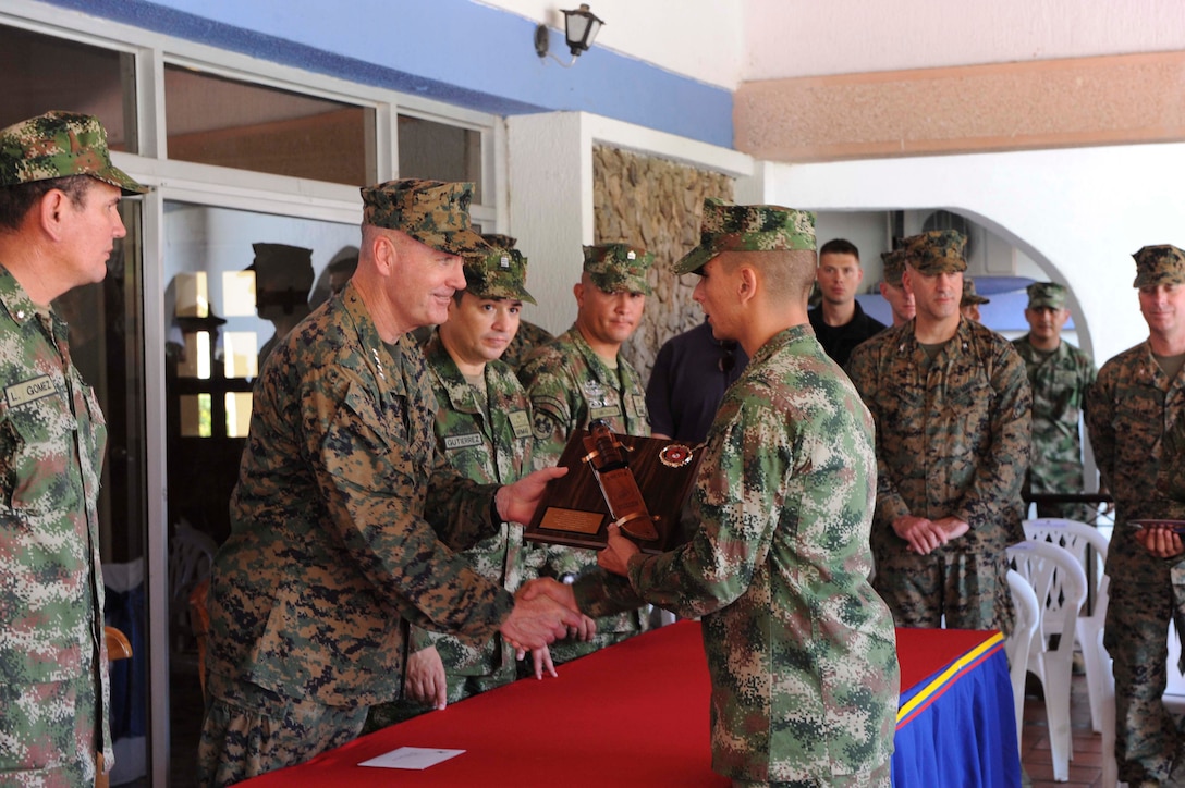Assistant Commandant of the Marine Corps Gen. Joseph F. Dunford presents an engraved K-Bar knife plaque to 2nd Lt. David Garcia Palacios May 24 at a training base in Covenas, Colombia. Palacios was the honor graduate of the second Colombian Marine Corps’ Officers Tactical Course. It’s a new course for the Colombian Marine Corps and its curriculum is largely based on The Basic School of the U.S. Marine Corps. Dunford toured the base during a two-day trip, where he met with embassy officials and Colombian naval leadership.