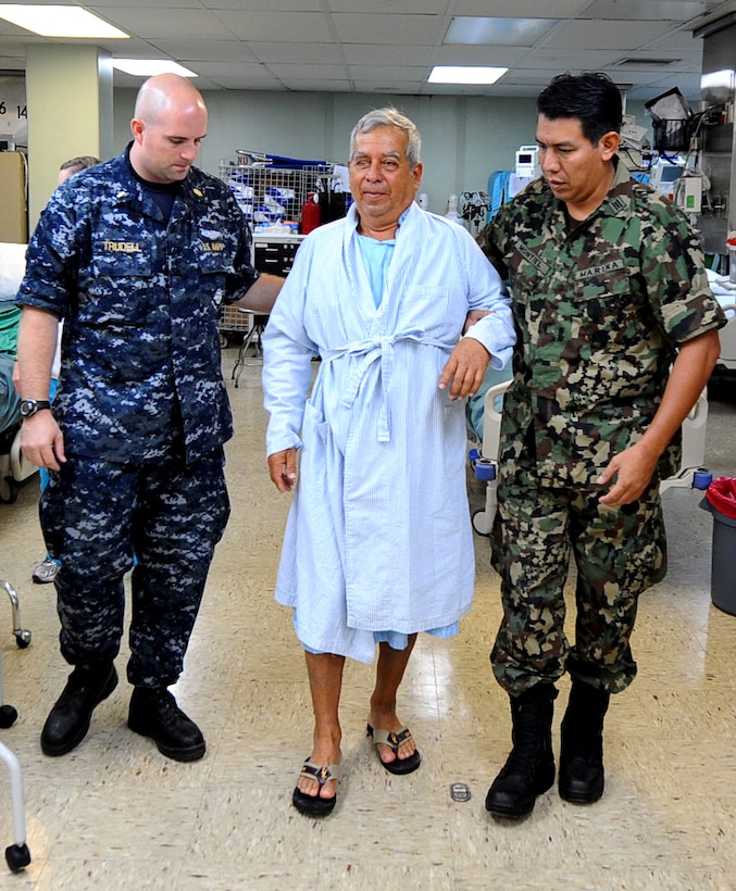 U.S. Navy Ensign Marshall Trudell and Mexican navy Lt. Fernando Montiel assist a patient after his surgery aboard the Military Sealift Command hospital ship USNS Comfort in Manta, Ecuador, May 19, 2011. Trudell is a neonatal intensive care doctor and Montiel is a nurse from Vera Cruz, Mexico.