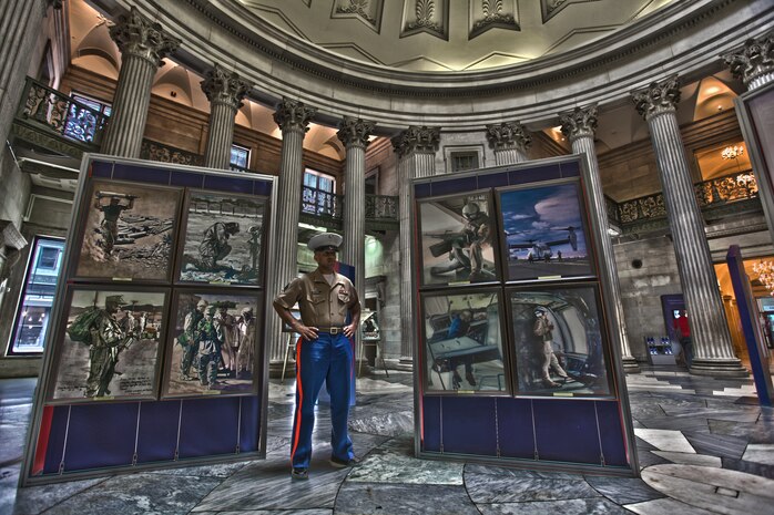 NEW YORK -- Sgt. Mohamed Mohamed, a New York native and personnel chief, 1st Marine Recruiting District, stands with the The National Museum of the Marine Corps Traveling Exhibit in Federal Hall. The exhibit contains a collection of paintings by Marines and is part of Fleet Week New York 2011. It is open from 9 a.m. to 5 p.m May 24 - 27, May 31 and June 1. More than 3,000 Marines, Sailors and Coast Guardsmen will be in the area participating in community outreach events and equipment demonstrations. This is the 27th year New York has hosted the sea services for Fleet Week. For more information on Fleet Week New York 2011 visit www.fleetweeknewyork.com. (Official Marine Corps HDR image by Sgt. Jimmy Shea  / RELEASED)