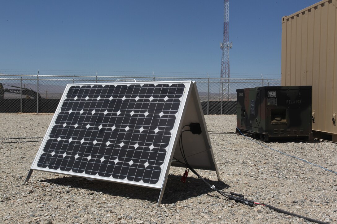 A solar panel soak up the desert sun outside of a generator it is helping provide power for outside the Marine Corps Training Operations Group headquarters at the Marine Corps Air Ground Combat Center Twentynine Palms, Calif. The Corps is testing several “green initiative” systems designed to boost generator power, cutting fuel costs and prolonging the generators’ life spans. (Official USMC photo by Sgt. Heather Golden)