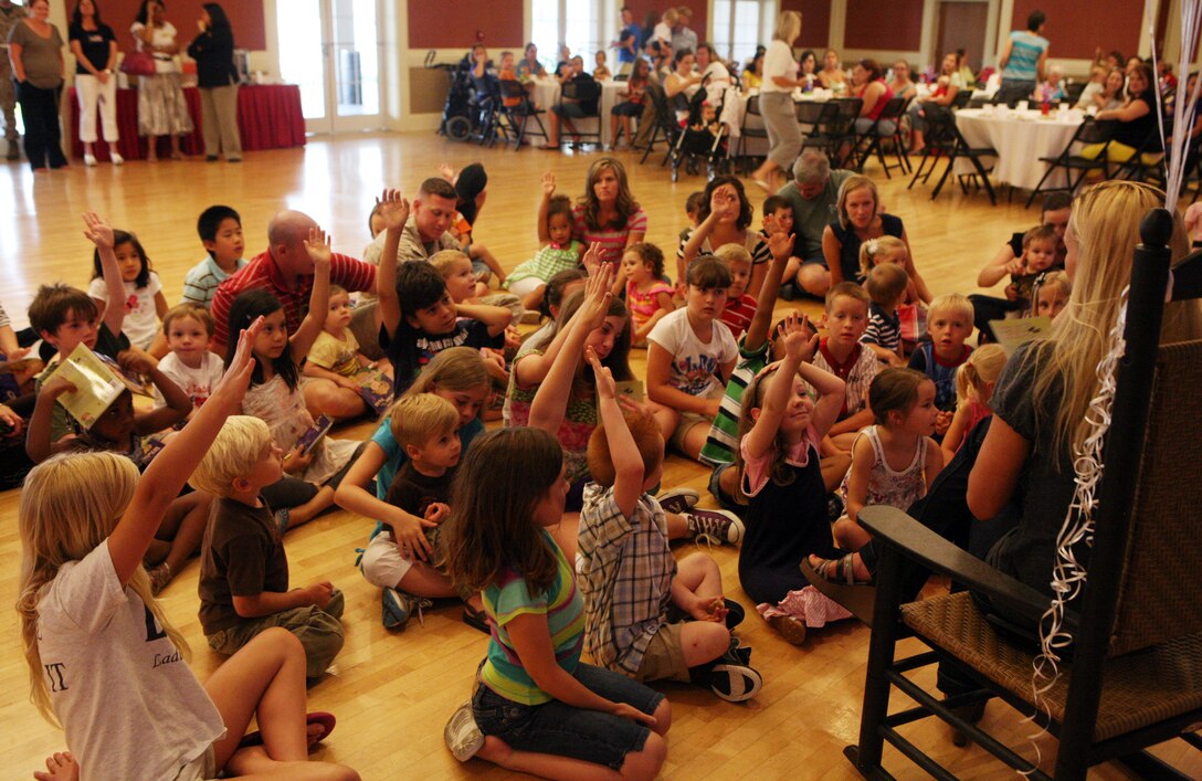 Children raise their hands to answer a question during the 2nd Marine Logistics Group story time event at Marston Pavilion aboard Camp Lejeune, N.C., May 25, 2011. The “Little Marine with a Flag” written by Carissa J. Marine was the book used for the event. (U.S. Marine Corps photo by Pfc. Franklin E. Mercado)