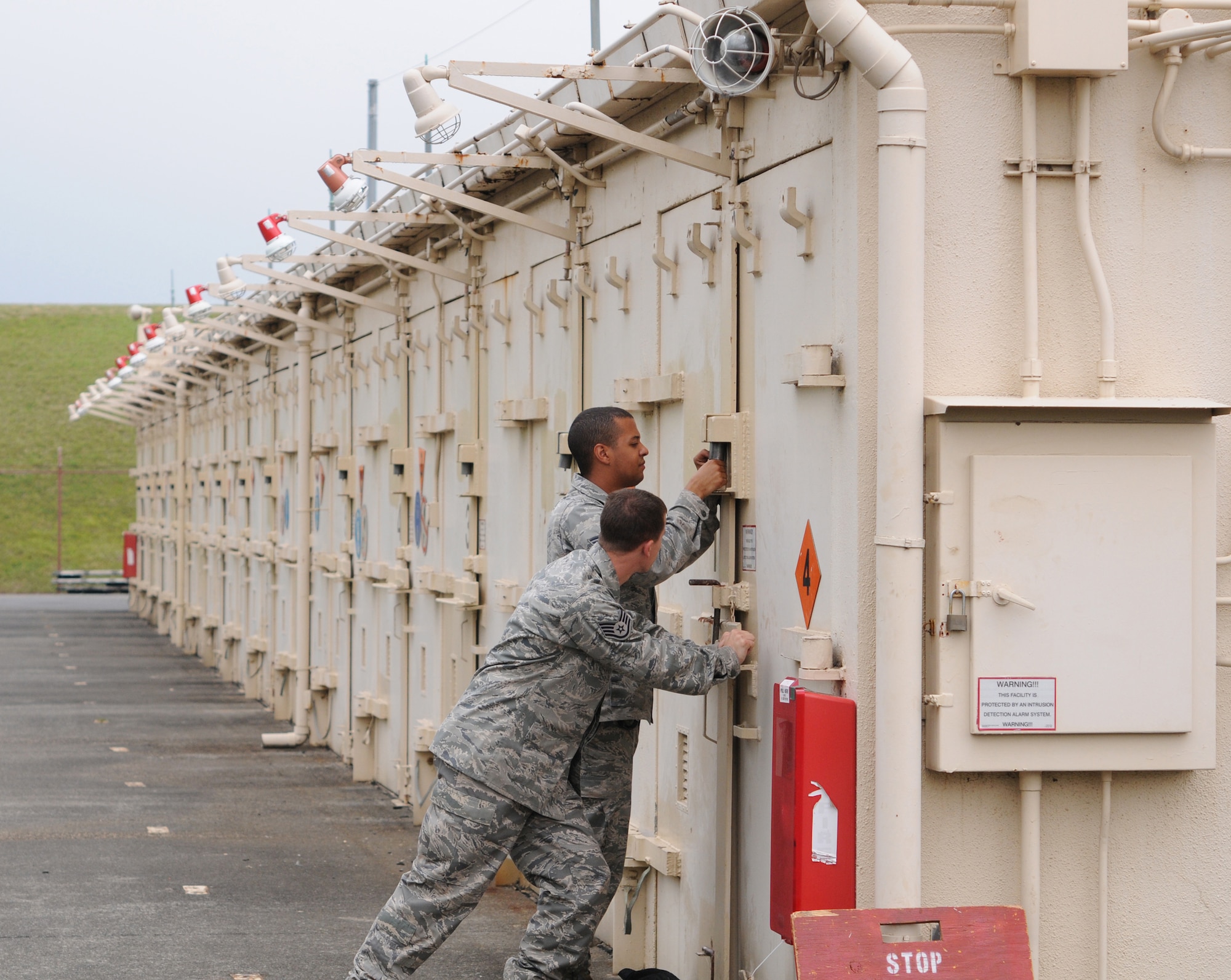 YOKOTA AIR BASE, Japan -- Staff Sgt. Jeffrey Holland, 374th Maintenance Squadron Munitions Flight stockpile surveillance crew chief (foreground), and Airman 1st Class Joshua Butler, 374th MXS stockpile surveillance crew member, lock multi-cube storage units May 26, 2011, at Yokota Air Base. The Munitions Flight maintains equipment to continuously improve the contingency capabilities of the 374th Airlift Wing and tenant units.  