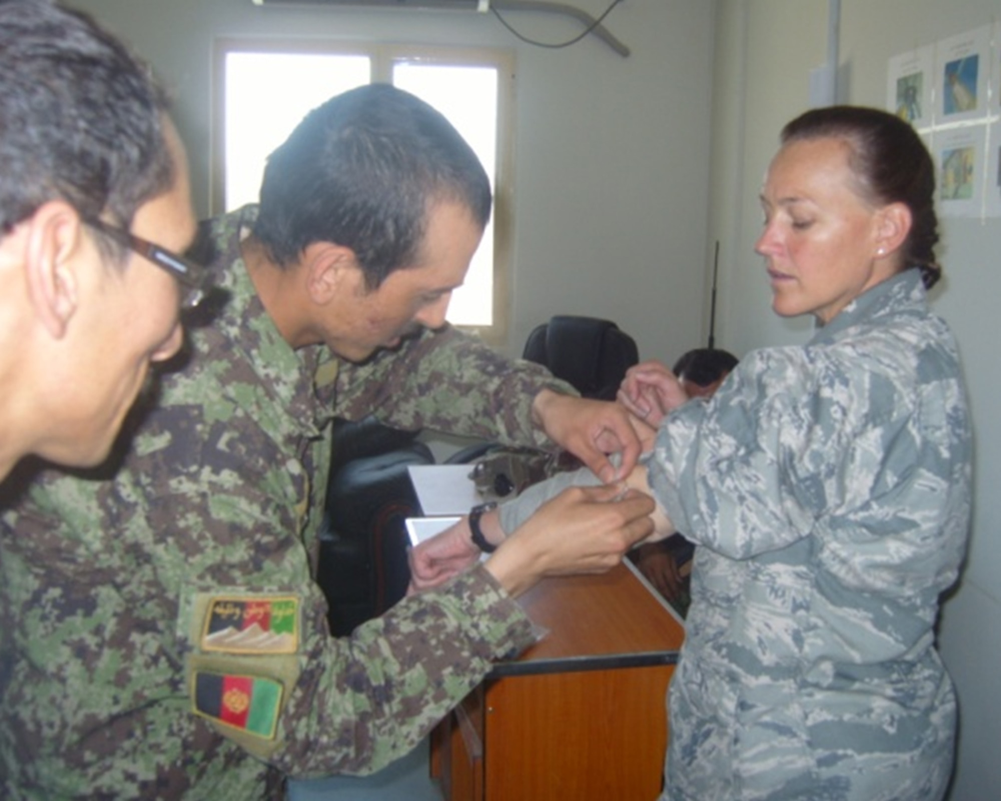 A U.S. Air Force advisor provides oversight as an Afghan air force firefighter applies a pressure dressing during a combat life saver course taught solely by Afghan flight medics May 22 at the Kabul Air Wing Fire Department. The focus of the training was on equipment familiarization and basic life saving steps and hands on techniques to treat wounded soldiers. (U.S. Air Force courtesy photo)