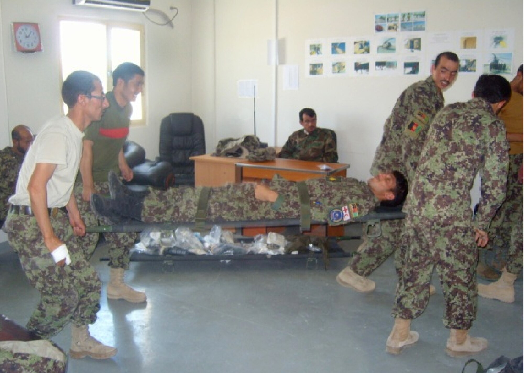 Afghan air force firefighters team up to safely move a "patient" during a combat life saver course May 22 at the KAW Fire Department. A U.S. Air Force advisor provided oversight as Afghan flight medics taught the day-long course. The focus of the training was on equipment familiarization and basic life saving steps and hands on techniques to treat wounded soldiers. Kabul Air Wing medics also taught various carries and proper litter support for transporting patients.(U.S. Air Force courtesy photo)