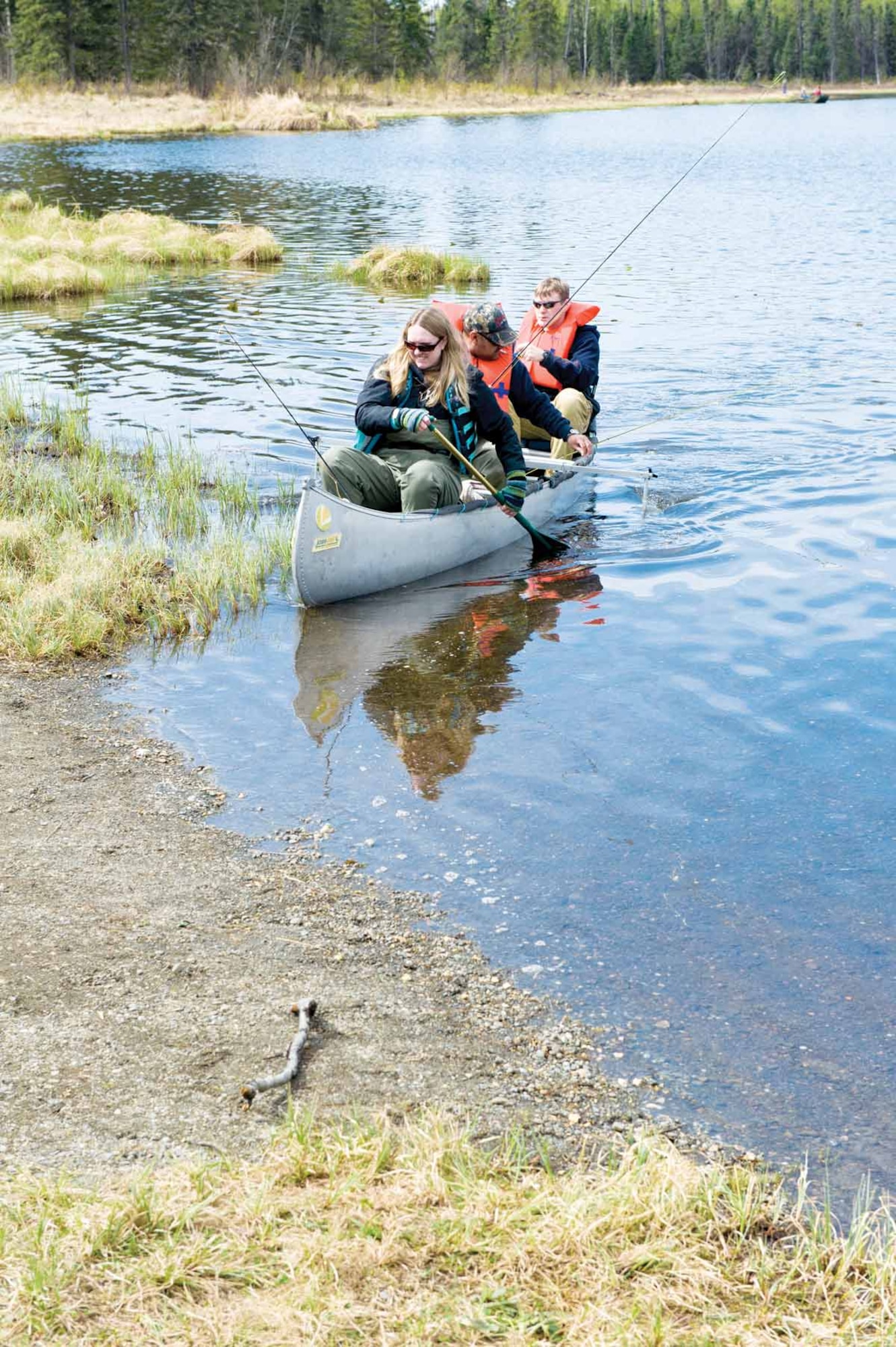Janelle Clough, her fiancé Sgt. Juan Aguilar of the Warrior Transition Battalion, and Sgt. George Campbell, also with the Warrior Transition Battalion, paddle back in from fly fishing on Green Lake. (U.S. Air Force photo/Johnathon Green)