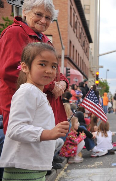 Onlookers at the Armed Forces Torchlight Parade show their appreciation and patriotism for military members at the 73rd Annual Lilac Festival during the Armed Forces Torchlight Parade May 21, 2011 Spokane, Wash. (U.S. Air Force photo/ Senior Airman Natasha E. Stannard)