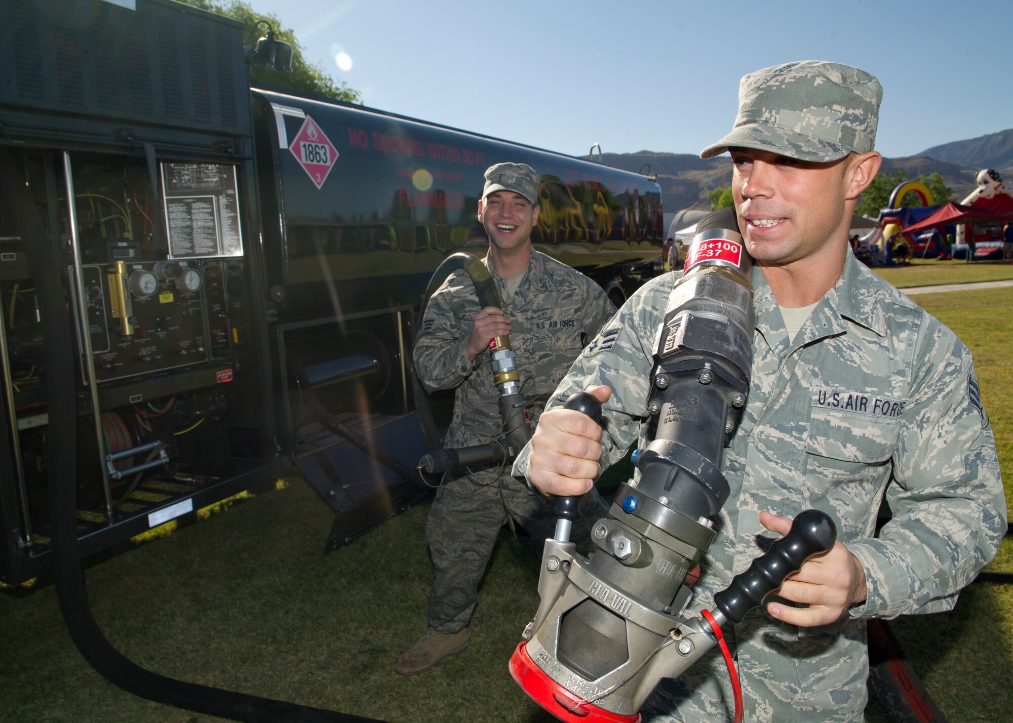 ALAMOGORDO, N.M. -- Senior Airmen Lucas King and William Simmons, both from the 49th Logistics Readiness Squadron Fuels Management Flight, hold non-collapsible hoses to show how fuel is transferred to a jet during Armed Forces Day, May, 21, 2011, at Washington Park. Airmen from the 49th LRS also demonstrated how to use a single-point nozzle and an over-the-wing nozzle from an R-11 Mobile Refueling Unit. (U.S. Air Force photo by Senior Airman Veronica Stamps/Released)