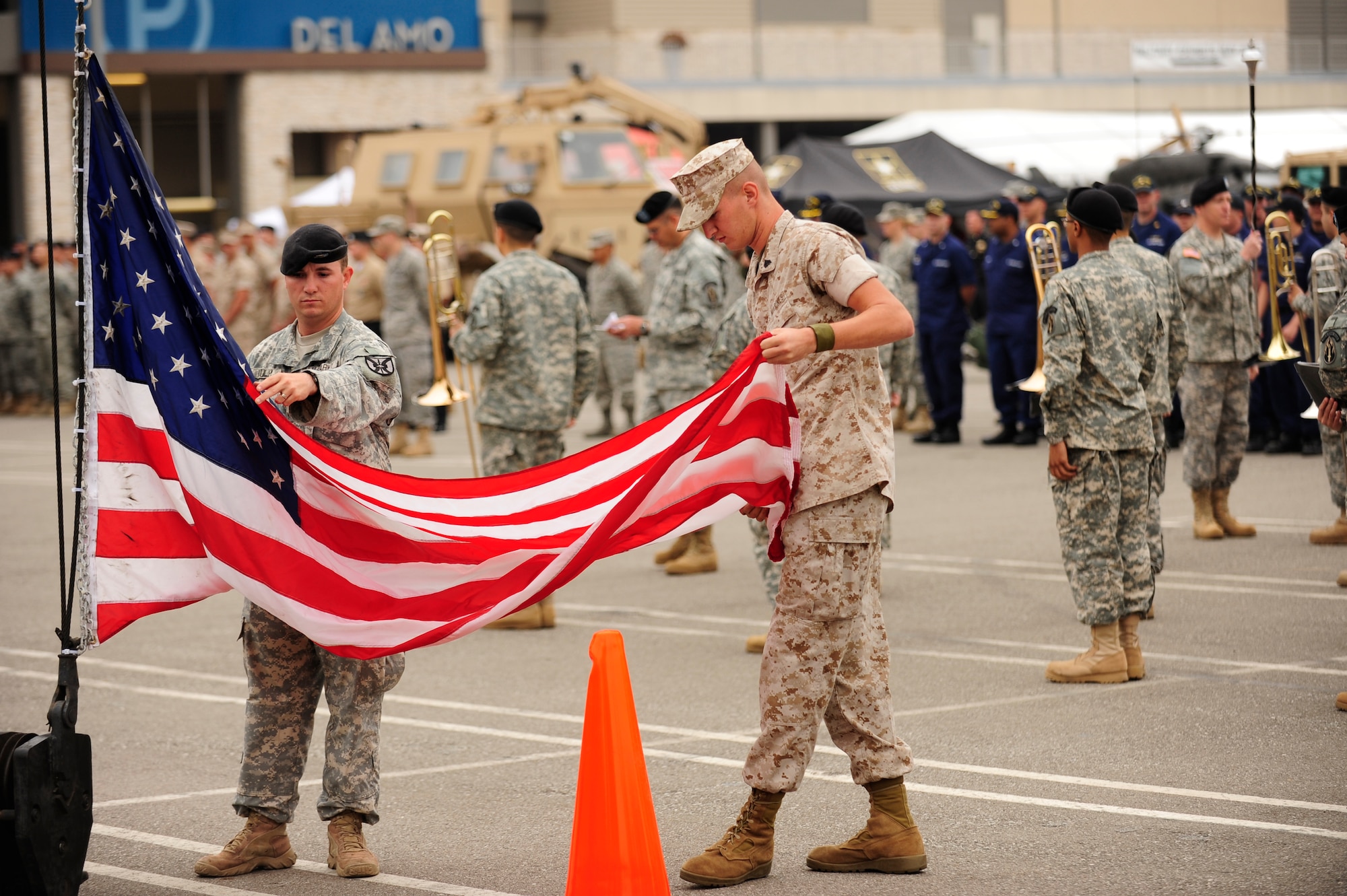 TORRANCE, Calif. -- A Marine  and a Soldier prepare the flag to be raised during the reveille ceremony at the Del Amo center during Armed Forces Day Saturday, May 21, 2011.  The ceremony was the first event of the 52nd Annual Armed Forces Day parade here.  (U.S. Air Force photo/Staff Sgt. Andrew Satran) 

   
 