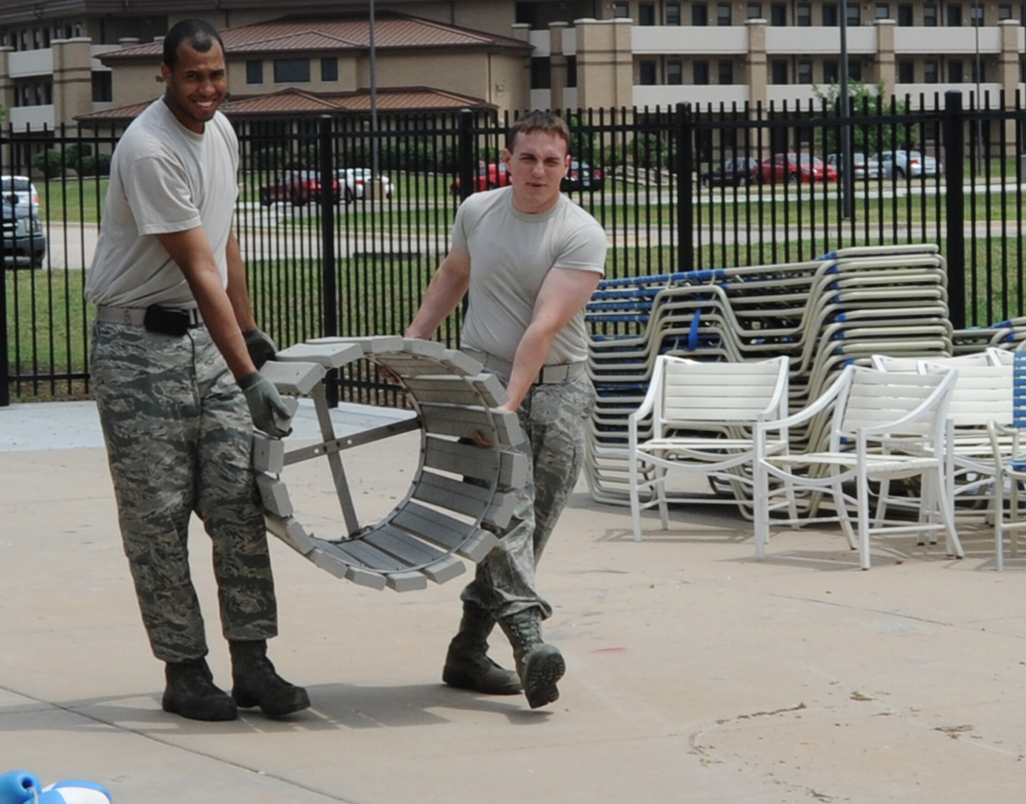 Tech. Sgt. Ralph Ortiz, 22nd Force Support Squadron base honor guard NCOIC and Senior Airman Kevin Yeates, 22nd Force Support Squadron base honor guard member, carry a new trash receptacle for the outdoor pool deck area May 23, 2011, McConnell Air Force Base, Kan. Members of the base honor guard prepared for the reopening of the outdoor pool May 27, 2011, after it was closed for renovations and improvements. (U.S. Air Force photo/Airman 1st Class Laura L. Valentine)