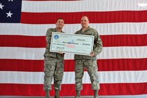 MINOT AIR FORCE BASE, N.D. -- Innovative Development through Employee Awareness award winner, Master Sgt. Joseph Saldan, 91st Missile Maintenance Squadron NCO in charge of the Electro-Mechanical Team section, receives a check for 10,000 dollars from Lt. Col. Joel Hanson, 91 Maintenance Group Commander here May 18. Air Force Global Strike Command awarded a maximum payout of $10,000 for his submission to the IDEA program. The program encourages Airmen and Air Force employees to look for ways of doing the Air Force business, faster, better and cheaper. (U.S. Air Force Photo/Senior Airman Jesse Lopez)