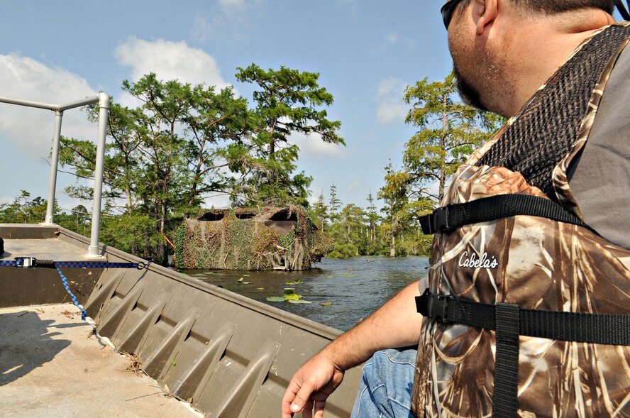 Mark Gates, 2nd Civil Engineer Squadron, glances at a duck blind that is in Flag Lake on Barksdale Air Force Base, La., May 24. Duck blinds are cover devices for hunters, designed to reduce the chance of detection.(U.S. Air Force photo/Senior Airman Kristin High)(RELEASED) 