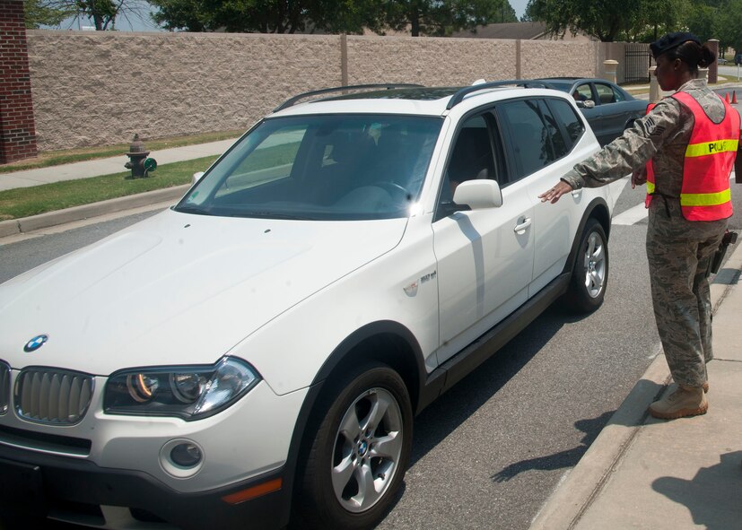 Staff Sgt. Mekesha Vinson, 23rd Security Forces Squadron, communicates with a driver May 24. In support of the Click-It or Ticket campaign, Sergeant Vinson ensured all drivers and passengers wore seatbelts. She also checked for drivers using cell phones. (U.S. Air Force photo/Airman 1st Class Paul Francis)(RELEASED)