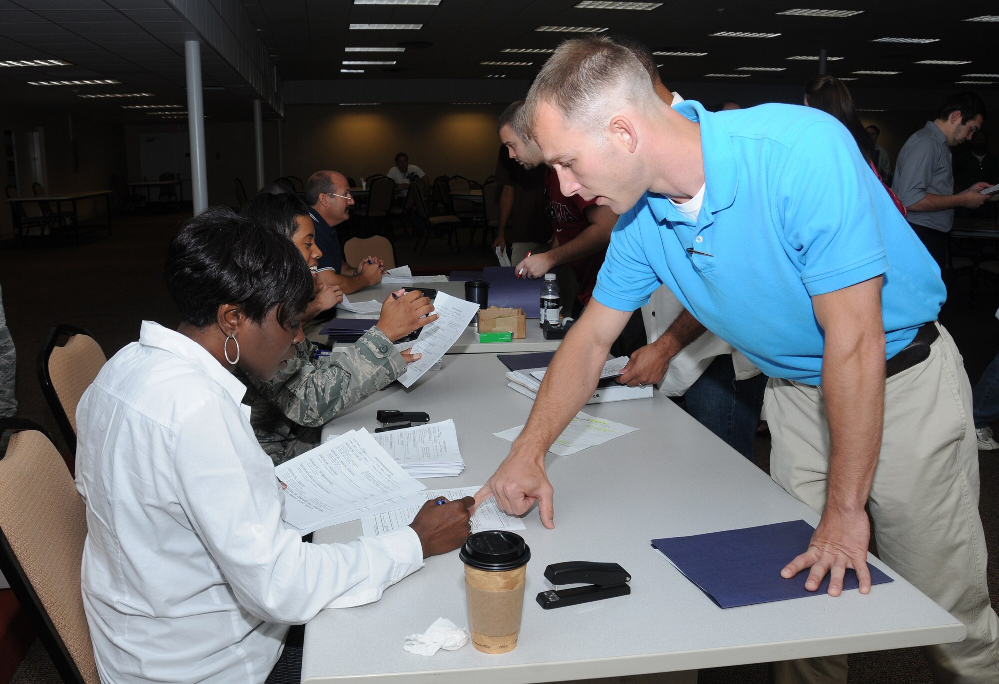Ruby Bordley, left, 81st Force Support Squadron, processes paperwork for Senior Airman Jerry Scoggins, McComb, Miss., during Monday’s Individual Ready Reserve
muster at the Dragon’s Lair. These IRRs have separated from active duty, but still have
a military service obligation, so the muster ensures that members are ready for possible mobilization or augmentation. About 170 IRRs within a 150-mile radius of Keesler had medical screenings, updated paperwork and received briefings.  (U.S. Air Force photo by Kemberly Groue)
