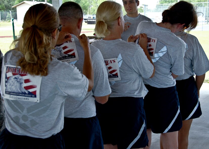Several 919th Special Operations Wing reservists team up to affix runner numbers to their fellow participants' shirts prior to Duke Field's 2011 Armed Forces Adult 5K fun run during the May unit training assembly.  The fun run was held to promote fitness and celebrate Armed Forces Day.  (U.S. Air Force photo/Staff Sgt. Jennifer Babb)