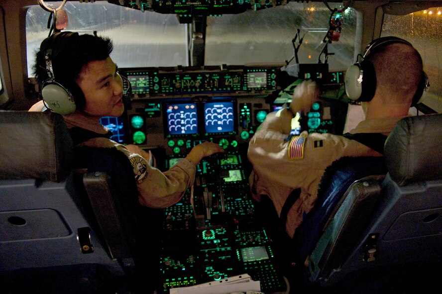 Capts. Raymond Jang (left) and Timothy Siemer conduct engine startup procedures on a C-17 Globemaster III on April 15, 2011, in Southwest Asia, prior to a mission. Both captains are assigned to the 816th Expeditionary Airlift Squadron. (U.S. Air Force photo/Master Sgt. Adrian Cadiz)