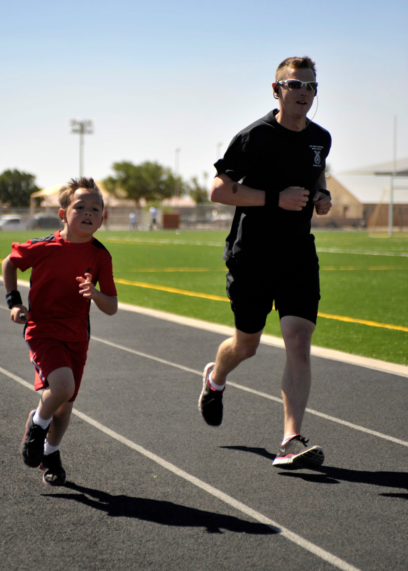 U.S. Air Force Tech. Sgt. Robert Wilson, 27th Special Operations Security Forces Squadron, and son Tyler, 7, sprint to the finish of the two mile race during the America's Kids Run, at Cannon Air Force Base, N.M. May 21, 2011. Sergeant Wilson and Tyler were two of approximately 70 parents and children that competed in the morning's events. (U.S. Air Force photo by Airman Ericka Engblom)