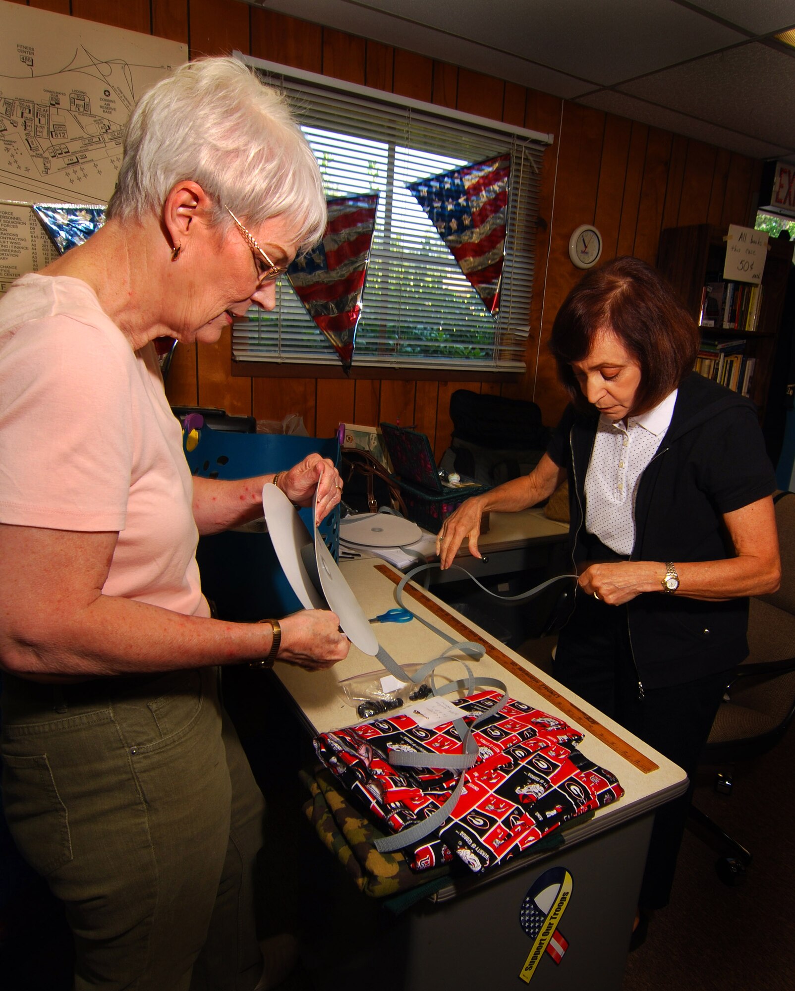 Kathleen Sisk and Adele Syracuse prepare the cut fabric, Velcro, buttons, and anything else needed for a pair pants and put that kit together into a zip-lock bag to streamline the process and keep the sewers sewing.  Adele is not a sewer but she is still a big help in the efficient process they have established, as she says anyone can participate all you have to do is want to volunteer to help a wounded warrior.    (U.S. Air Force photo/ Brad Fallin) 