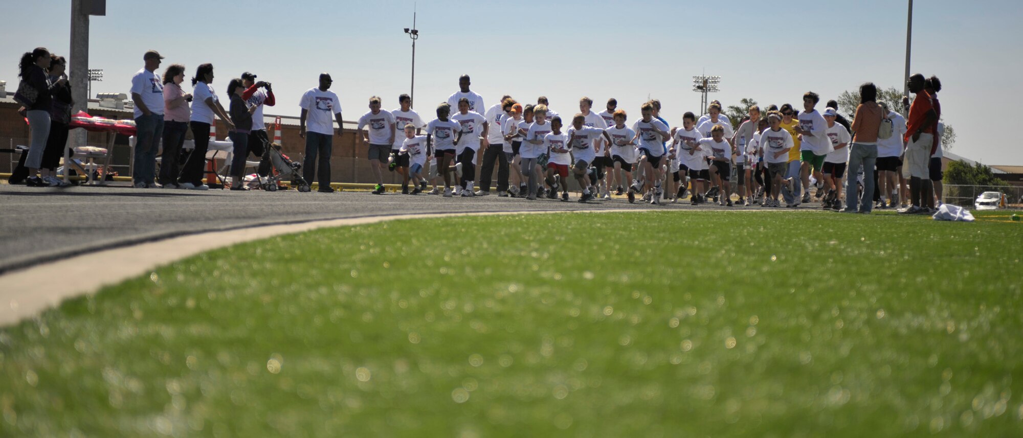 The participants of the America's Kids Run begin their respective half mile, mile, two mile, and 5K races at the Cannon Air Force Base track, May 21, 2011. Children and parents alike competed in the morning's events which were put in place to support May as National Fitness Month. (U.S. Air Force photo by Airman Ericka Engblom) 