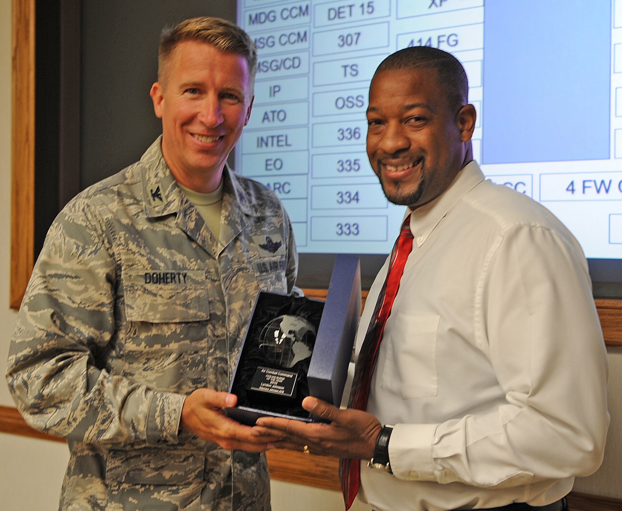 SEYMOUR JOHNSON AIR FORCE BASE, N.C. -- Col. Patrick Doherty, 4th Fighter Wing commander, presents an Air Combat Command award for outstanding achievement as a clinical nurse to Lyndon Johnson. (U.S. Air Force photo/Senior Airman Gino Reyes)(Released)

