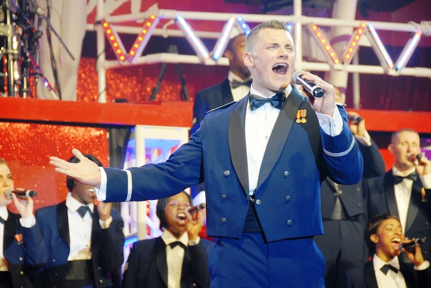 2nd Lt. Robert Doyle, 2011 Tops in Blue vocalist and officer in charge, sings the lead for a patriotic song during the group's dress rehearsal May 20 at Kelly Air Force Base, Texas. The 2011 Tops in Blue team is set to kick off their 'Rhythm Nation' tour with a performance at Barksdale Air Force Base, La., tonight. The show provides a glimpse of a century of popular music and how it grew through new rhythms and technology. Lieutenant Doyle is an aquisitions program manager from Vandenberg Air Force Base, Calif. (U.S. Air Force photo/Erin Tindell)