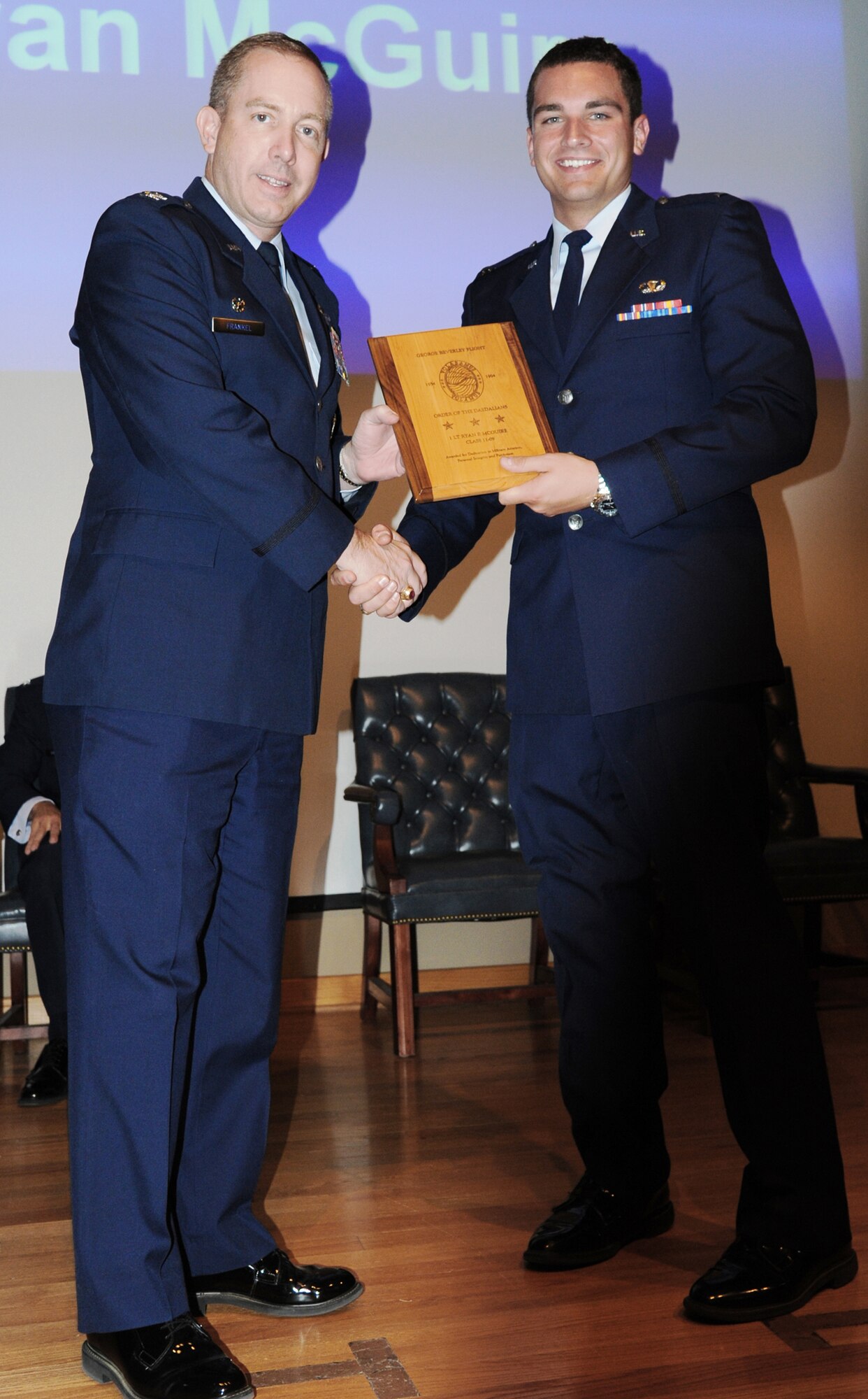 First Lt. Ryan McGuire (right) accepts the Daedalian Award from Col. Michael Frankel, the 47th Flying Training Wing commander, during graduation from Specialized Undergraduate Pilot Training May 20, 2011, at Laughlin Air Force Base, Texas. Lieutenant McGuire became the first person to graduate Air Force pilot training as an amputee. He is assigned to the 47th Operation Support Squadron. (U.S. Air Force photo/Airman 1st Class Blake Mize)