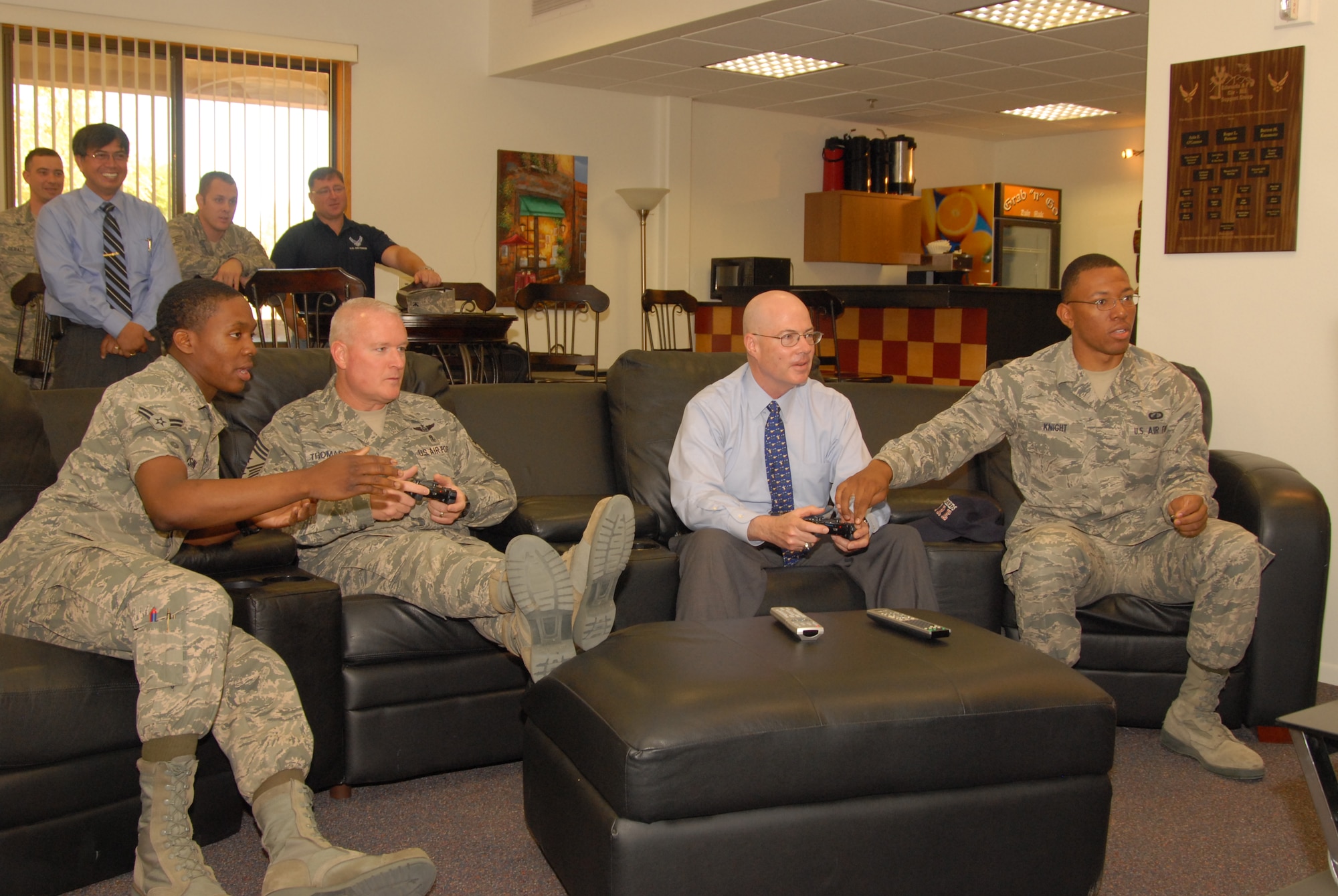Left to right: Airman 1st Class Shalom Voisin, 95th Medical Operations Squadron, Chief Master Sgt. Bill Thomaston, 95th Air Base Wing command chief, James Judkins, 95th Civil Engineering Division director, and Airman 1st Class Antawn Knight, 95th Comptroller Squadron, play Call of Duty on Higher Grounds Internet Café?s PlayStation 3. The café officially opened May 20 with a ribbon-cutting ceremony. Higher Grounds has three Xboxes, wireless and wired internet, and the PS3. It was moved to Bldg. 2511, which is centrally located in dormitory area. (Air Force photo by Kenji Thuloweit)