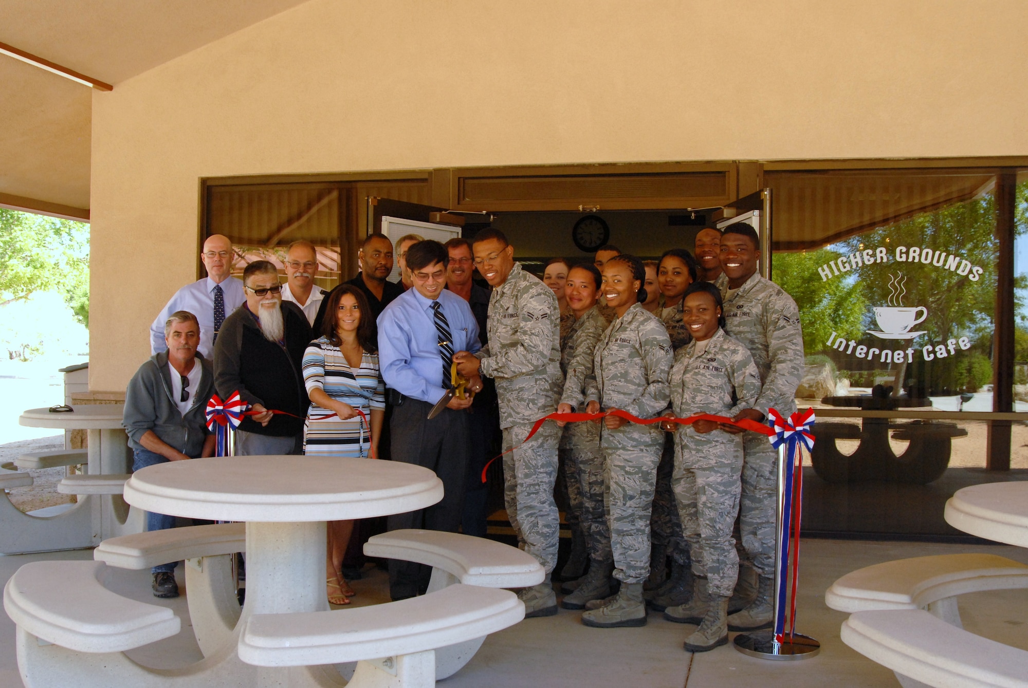 Pablo Publico, 95th Air Base Wing Civil Engineer Division Space Optimization team lead (center left), and Airman 1st Class Antawn Knight, 95th Comptroller Squadron (center right), cut the ceremonial ribbon to officially open up the new Higher Grounds Internet Café in Bldg. 2511, May 20, along with some members of Team Edwards who made the move happen. Higher Grounds was relocated to a more centralized place for Airmen in the dorms to hang out. (Air Force photo by Kenji Thuloweit)