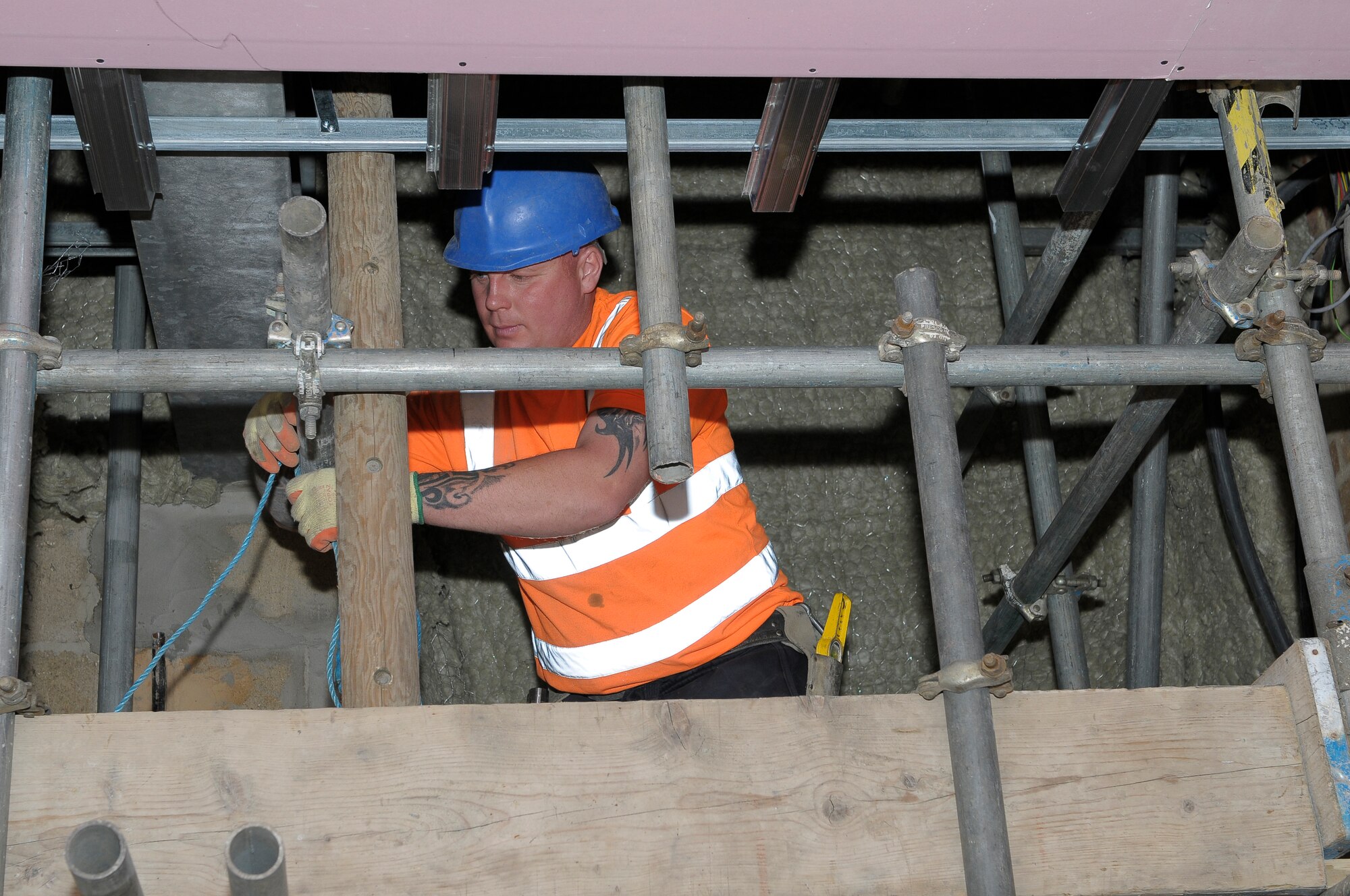 ROYAL AIR FORCE LAKENHEATH, England -- Pawel Orwat, construction worker with Vinci Facilities, works on a scaffold in the women's bathroom at the Knight's Table Dining Facility May 20, 2011. The dining facility will close from June 17 to Sept. 8 for upgrades to the building and its equipment. The DFAC will receive $850,000 worth of upgrades including improvements to the dining rooms, bathrooms, kitchen and front office areas. (U.S. Air Force photo/Staff Sgt. Connor Estes)