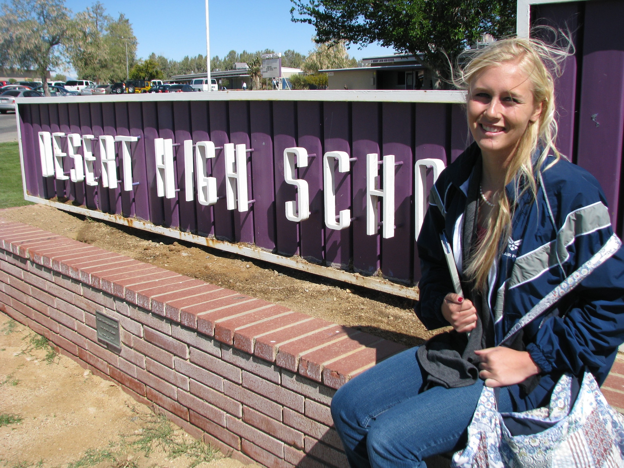 Desert Junior/Senior High School student Courtney Bishop sits in front of her high school alma mater, donning her college colors. Miss Bishop was selected as the 22nd Congressional District's principal nomination to the United States Air Force Academy in Colorado. She leaves for the Academy this June. (Air Force photo by Diane Betzler)