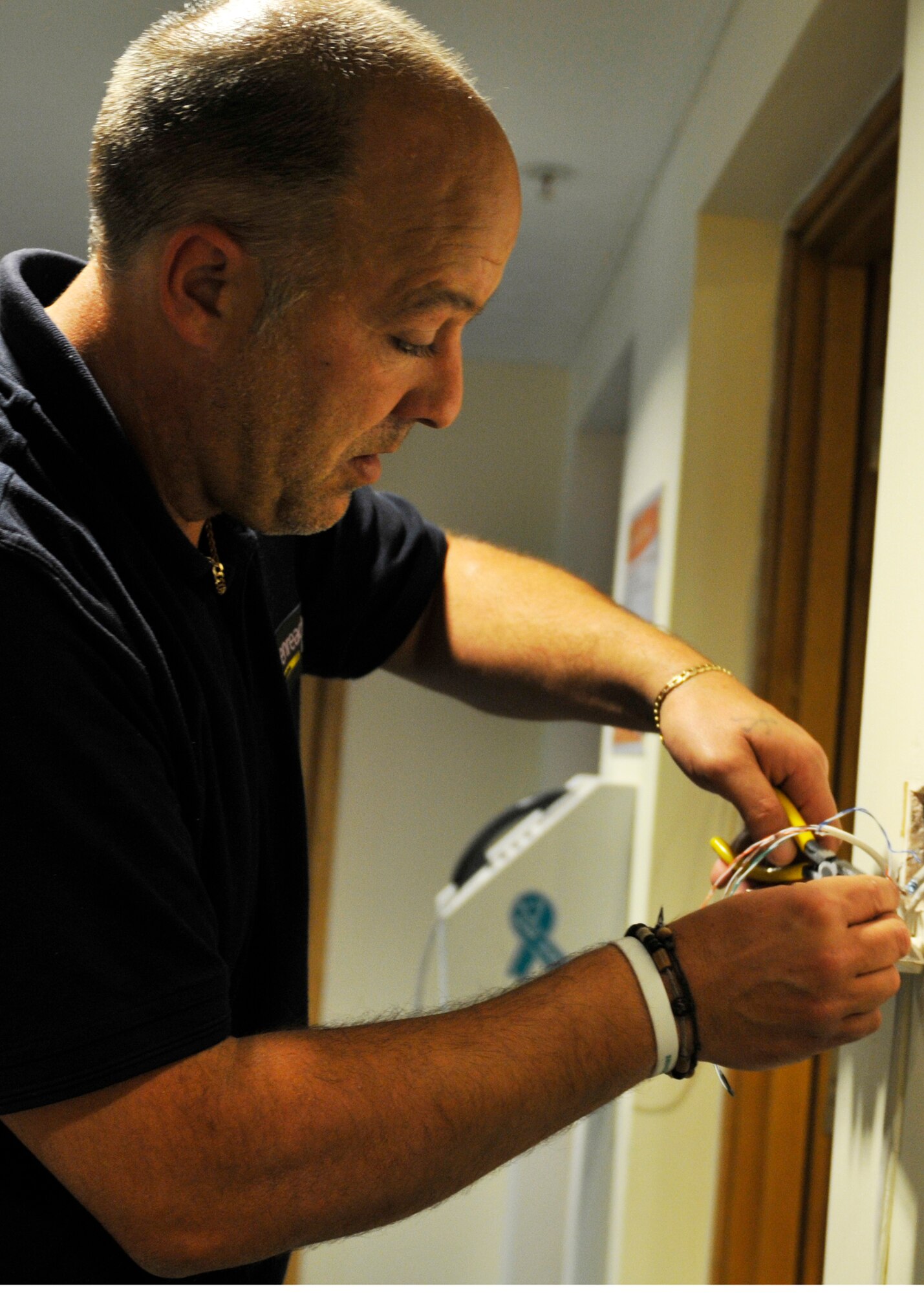 ROYAL AIR FORCE LAKENHEATH, England - Neil Rayner, British Telecom customer service engineer, terminates a spare pair of wires in preparation for Internet installation in a 852 dormitory day room, May 25, 2011. As a wing-driven initiative for Airmen, all dormitory day rooms will be receiving free wireless Internet in mid-June. (U.S. Air Force photo/Senior Airman Tiffany M. Deuel)