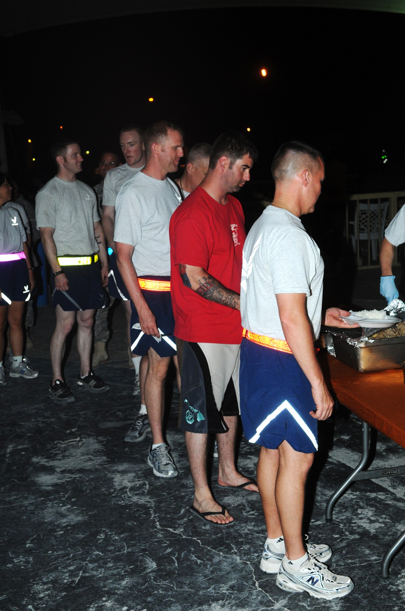 Members of the 379th Air Expeditionary Wing line up for food during the Asian Luau May 21 in Southwest Asia.  The event was held by members of the 379th Asian Pacific American Assoication.(U.S. Air Force photo/ Staff Sgt. Anthony Graham)