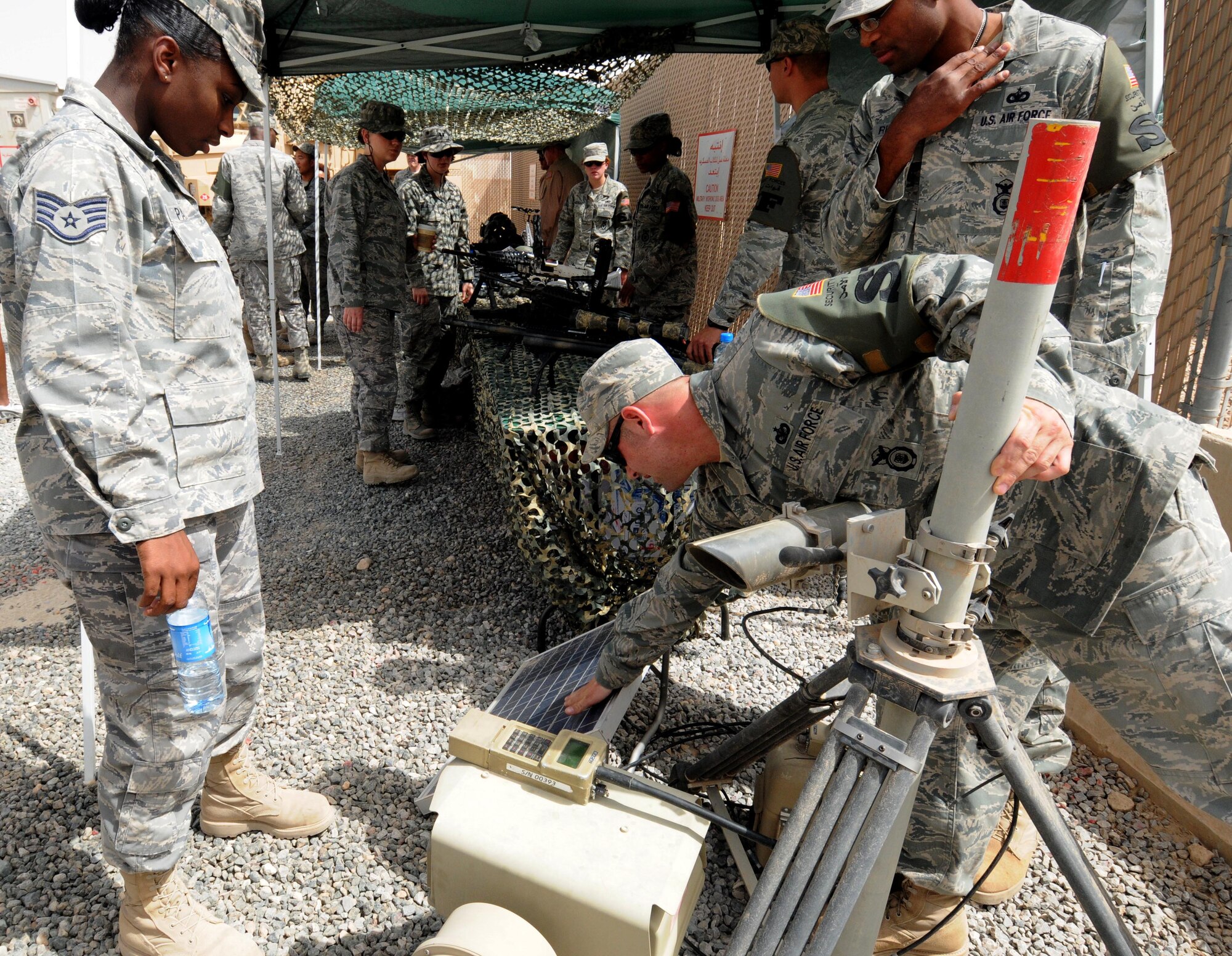 Staff Sgt. Nathan Fehr, a Defender with the 386th Expeditionary Security Forces Squadron, explains the solar panels on a piece of detection equipment to Staff Sgt. Deanna Parsons, a material management journeyman with 386th Expeditionary Logistics Readiness Squadron during the Security Forces Open house May 11 at an undisclosed location in Southwest Asia. Defenders with the 386th and 387th ESFS held a multitude of events to celebrate and honor Police Week. (U.S. Air Force photo by Staff Sgt. Patrice Clarke)
