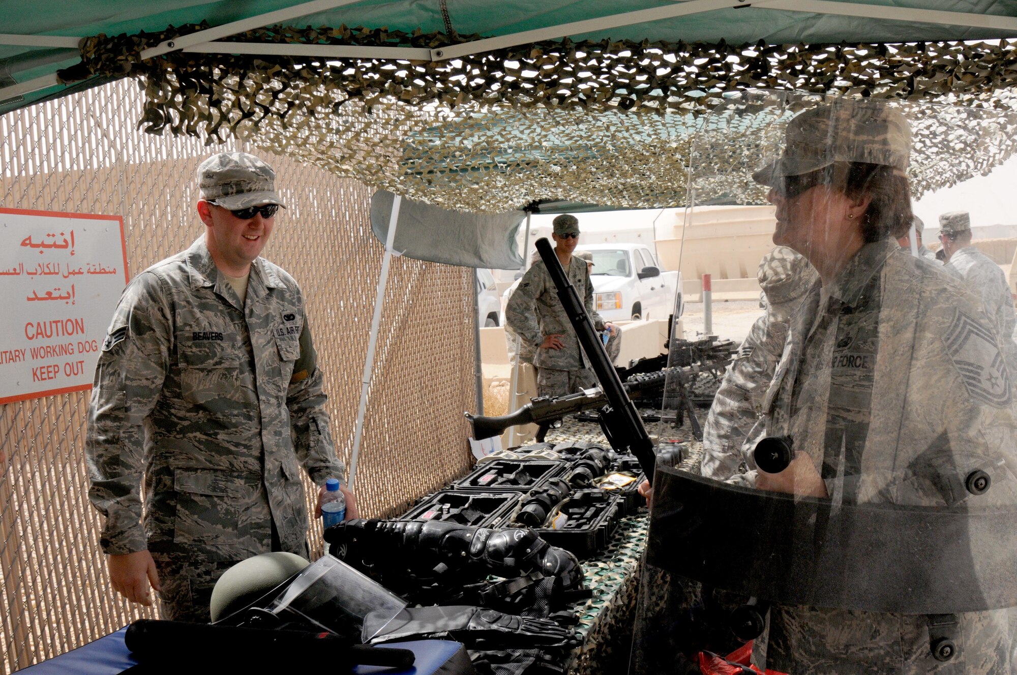 Senior Airman Samuel Beavers, a Defender with the 386th Expeditionary Security Forces Squadron, shows Chief Master Sgt. Nathalie Swisher, 386th Expeditionary Mission Support Group superintendent, the proper wear of riot gear May 11 at an undisclosed location in Southwest Asia. (U.S. Air Force photo by Staff Sgt. Patrice Clarke)