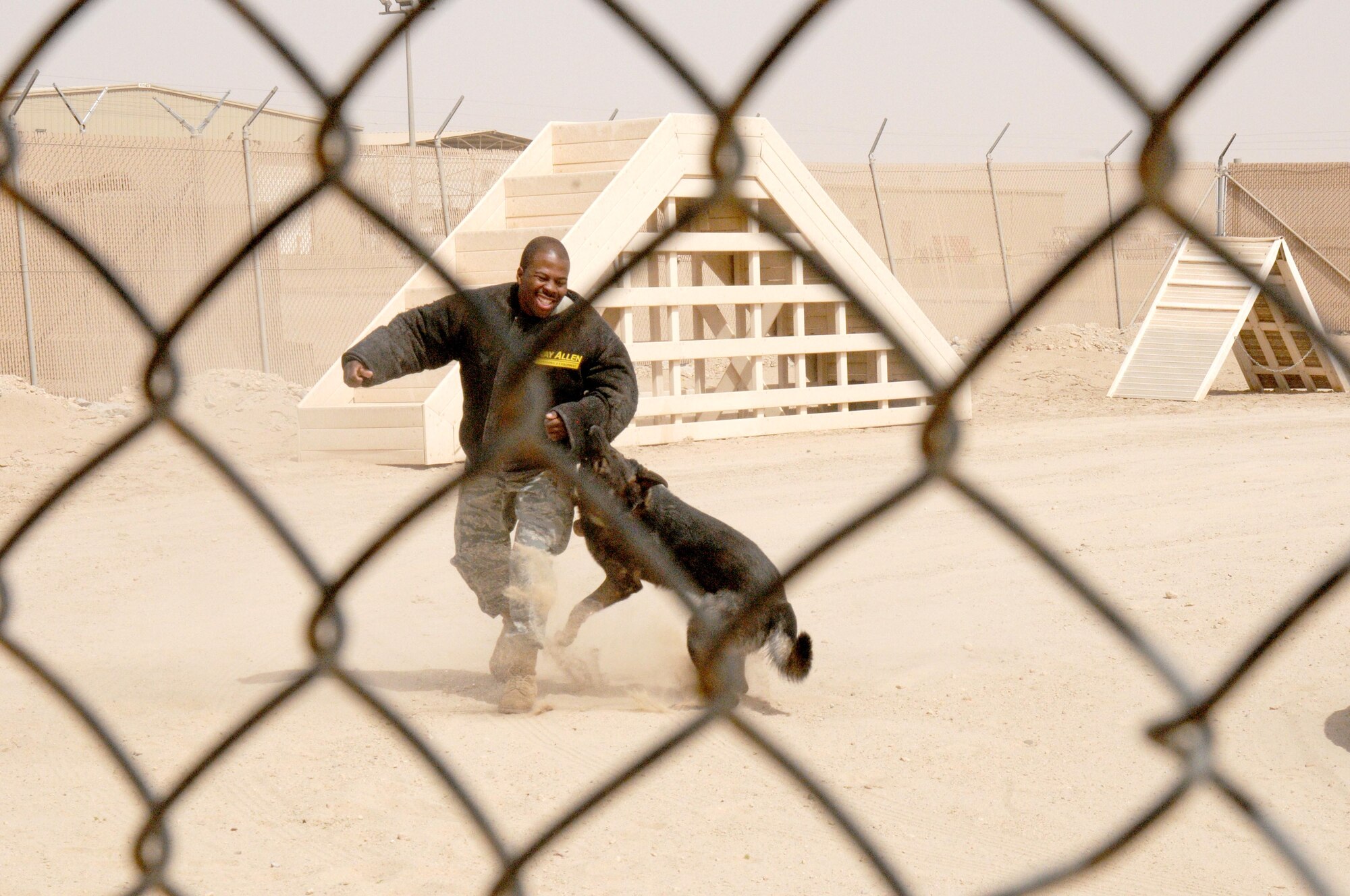 Staff Sgt. Dontarie Russ, a military working dog handler with the 386th Expeditionary Security Forces Squadron participates in a MWD demonstration with MWD Chrach. The 386th and 387th ESFS held numerous events May 9 - 13 to celebrate and honor Police Week. (U.S. Air Force Photo by Staff Sgt. Patrice Clarke)