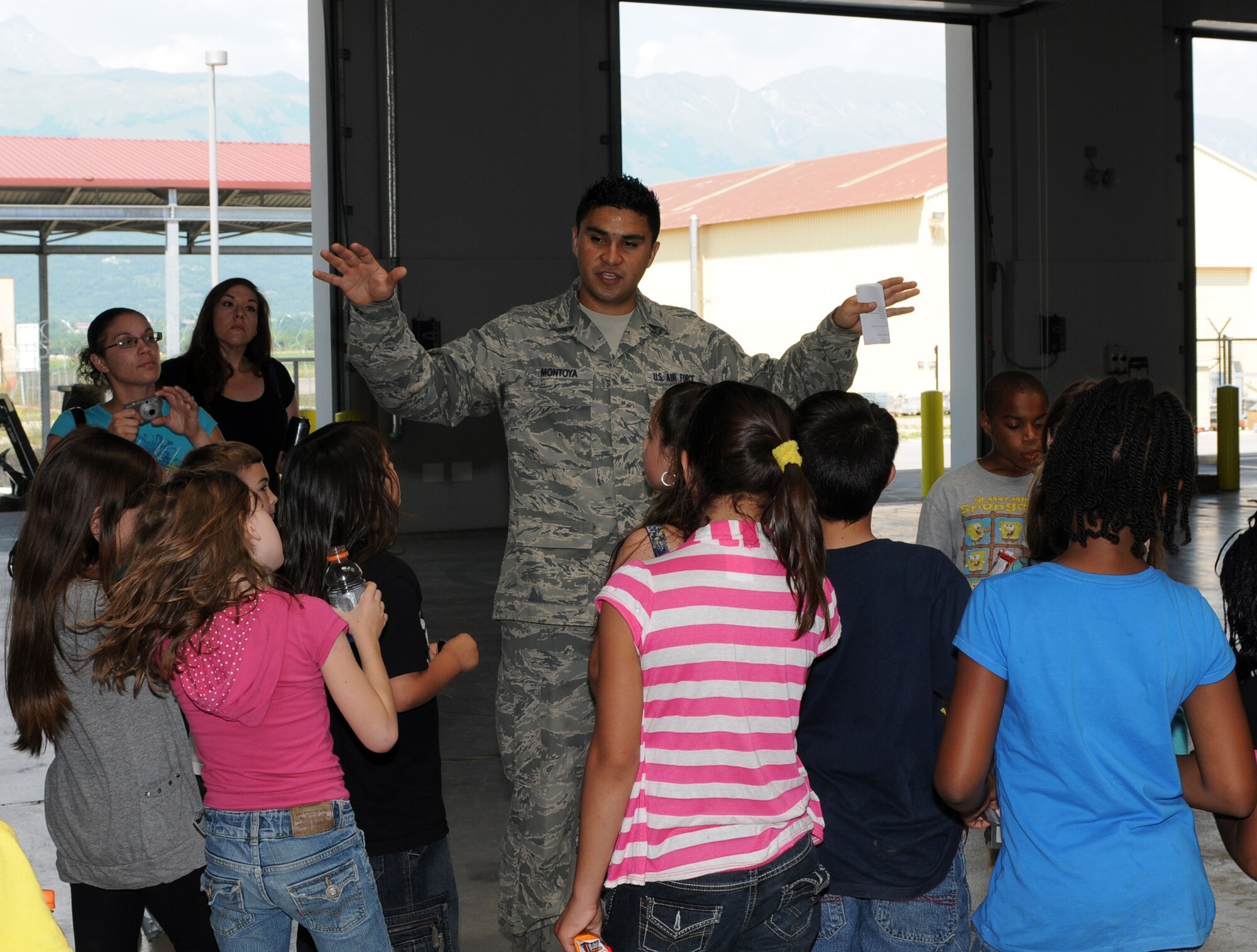 Staff Sgt. Frederick Montoya, 724th Air Mobility Squadron air terminal operations center information controller, gives a tour of the base passenger terminal aircraft services section to Aviano Elementary School third grade students May 24. The students also had the opportunity to see the 724th AMS Airmen in action. (U.S. Air Force photo/Staff Sgt. Julius Delos Reyes)