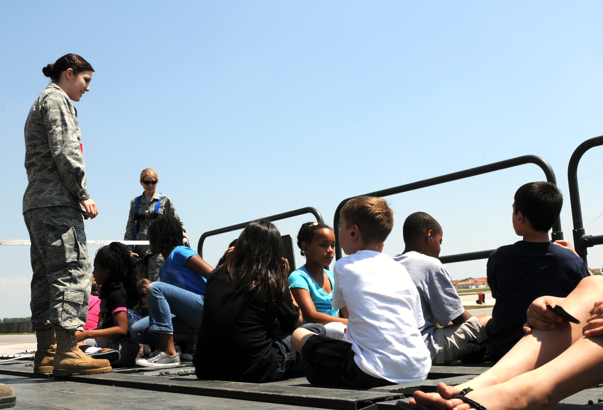 Second Lt. Kirsten Van Vuuren, 724th Air Mobility Squadron passenger service officer in charge, talks to Aviano Elementary School third grade students prior to being lifted by a loader vehicle used for loading aircraft at the base passenger terminal May 24. The students toured the unit's facility and had the opportunity to see the 724th AMS Airmen in action. (U.S. Air Force photo/Staff Sgt. Julius Delos Reyes)