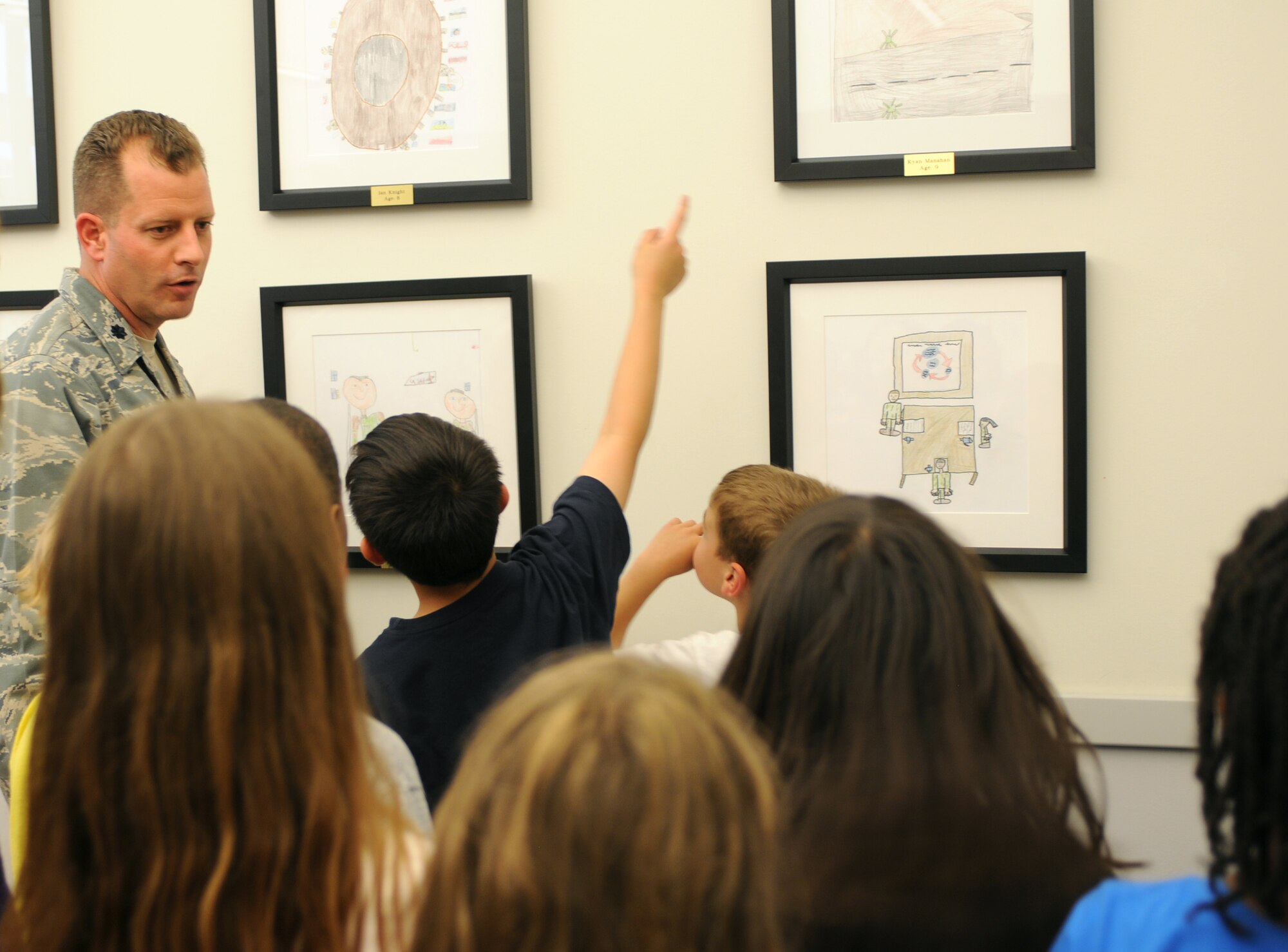 Lt. Col Scott Belanger, 724th Air Mobility Squadron, provides a tour of the base terminal to 15 third grade students with the Aviano Elementary School May 24. The 724th AMS showcased the art works that the students donated for the terminal’s children’s play area. In addition, the students also received the opportunity to see the 724th AMS Airmen in action. (U.S. Air Force photo/Staff Sgt. Julius Delos Reyes)
