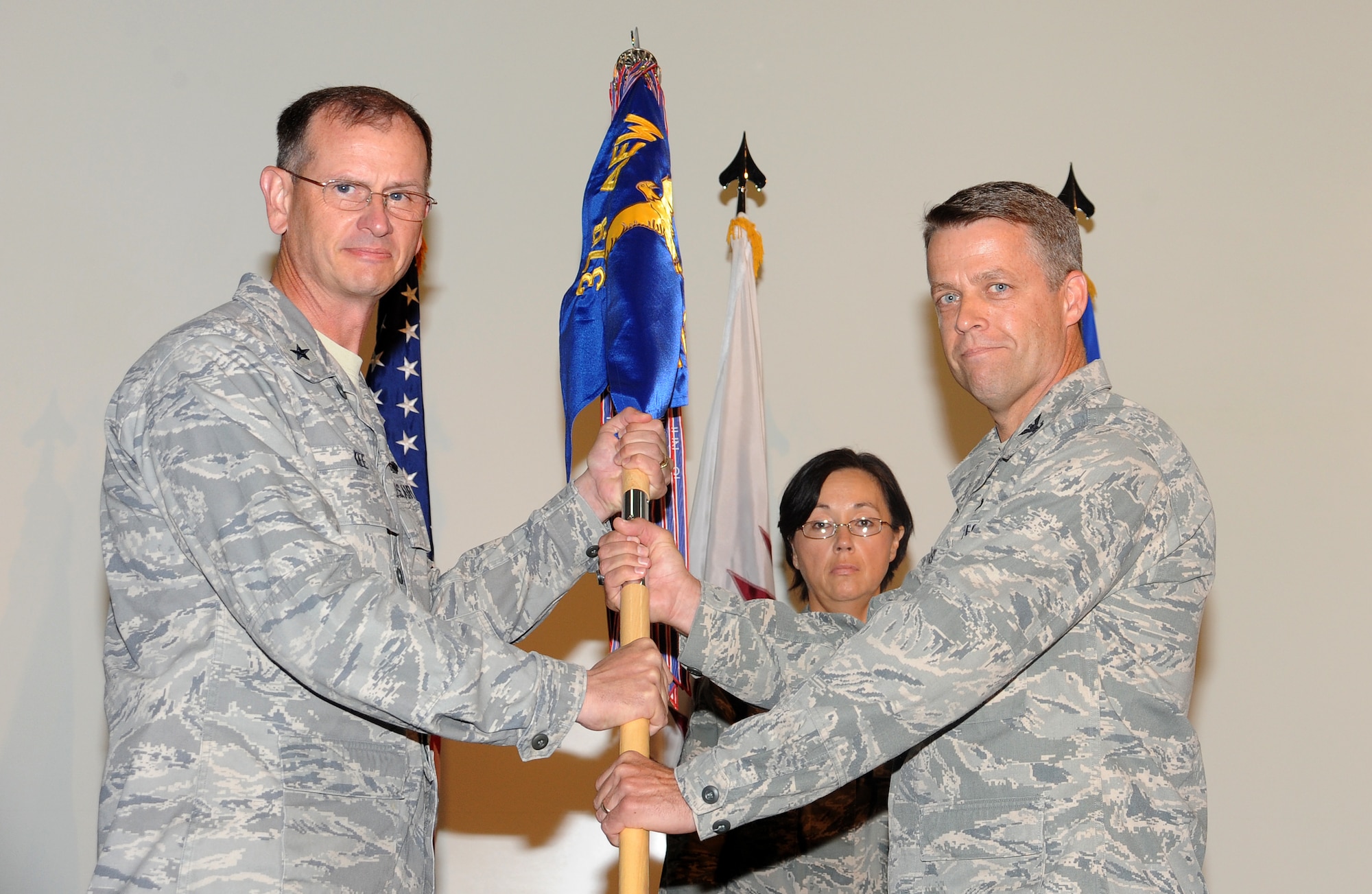 Brig. Gen. Randy Kee, 379th Air Expeditionary Wing commander, passes the 379th Expeditionary Mission Support Group guidon to the new commander, Col. James Pease, in a change of command ceremony May 25 in Southwest Asia. Colonel Pease assumed command of the 379 EMSG from Col. Korvin Auch. The 379 EMSG provides expeditionary combat support -- to include maintaining and sustaining base infrastructure valued at more than $2 billion, and security for more than $10 billion in critical assets. (U.S. Air Force photo/Staff Sgt. Liliana Moreno)                       