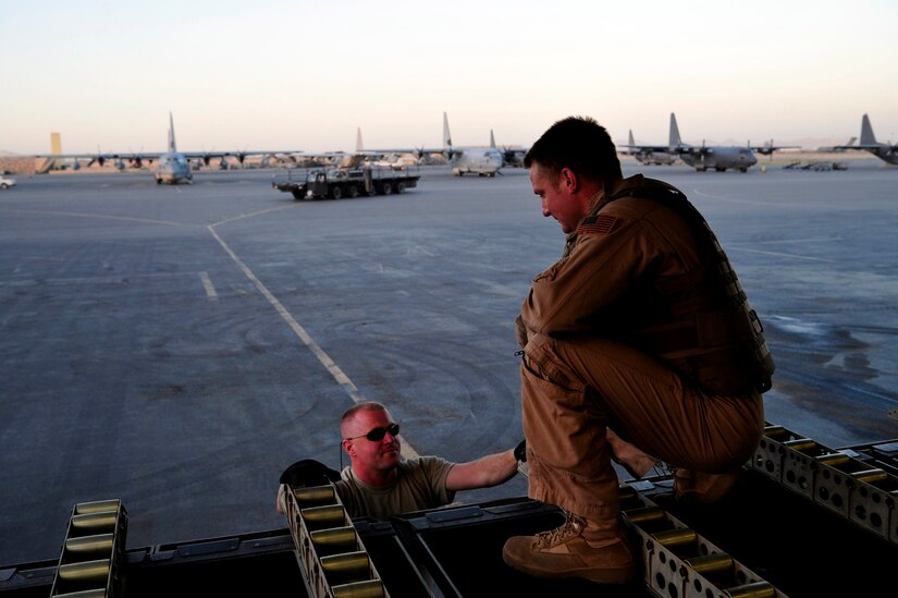 Staff Sgt. Doug Tadevich, 17th Airlift Squadron loadmaster, coordinates off-load operations with a member of the 451st Air Expeditionary Wing after landing at Kandahar Airfield, Afghanistan, in a flight from Mihail Kogalniceanu Air Base, Romania, May 20.  The crew flew a C-17 Globemaster III from MK airfield to Kandahar Air Base carrying critical cargo supporting Operation Enduring Freedom.  Several C-17s are temporarily deployed to MK from another base in the region that is closed for routine runway repairs.  (U.S. Air Force photo by Master Sgt. Laura K. Deckman/released)