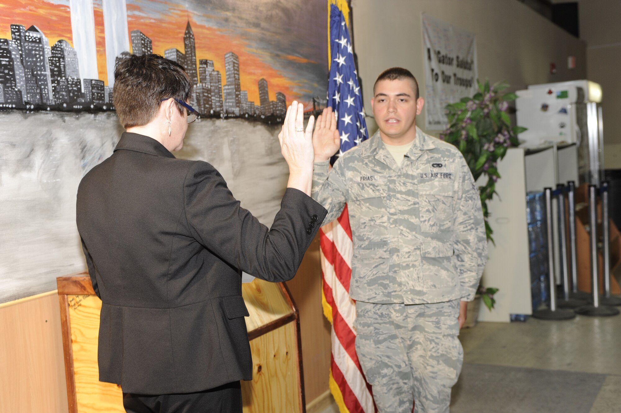 TRANSIT CENTER AT MANAS, Kyrgyzstan -- Ms. Susan Aikman, U.S. Citizenship and Immigration Management Field Office in Moscow, gives Airman 1st Class Jose Frias, 376th Expeditionary Logistics Readiness Squadron Passenger Terminal representative, the oath of allegiance in the PAX terminal here May 25.  
Airman Frias, a Tampico, Mexico native and two-years time in service said he's excited to be the first in his family to earn U.S. citizenship. (U.S. Air Force photo by Tech. Sgt. Jerome C. Baysmore)
