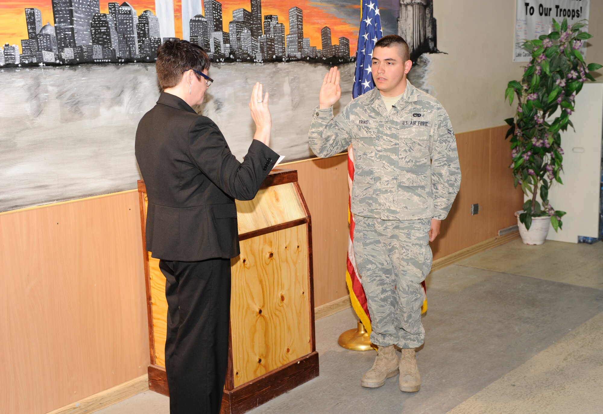 TRANSIT CENTER AT MANAS, Kyrgyzstan -- Ms. Susan Aikman, U.S. Citizenship and Immigration Management Field Office in Moscow, gives Airman 1st Class Jose Frias, 376th Expeditionary Logistics Readiness Squadron Passenger Terminal representative, the oath of allegiance in the PAX terminal here May 25.  
Airman Frias, a Tampico, Mexico native and two-years time in service said he's excited to be the first in his family to earn U.S. citizenship. (U.S. Air Force photo by Tech. Sgt. Jerome C. Baysmore)