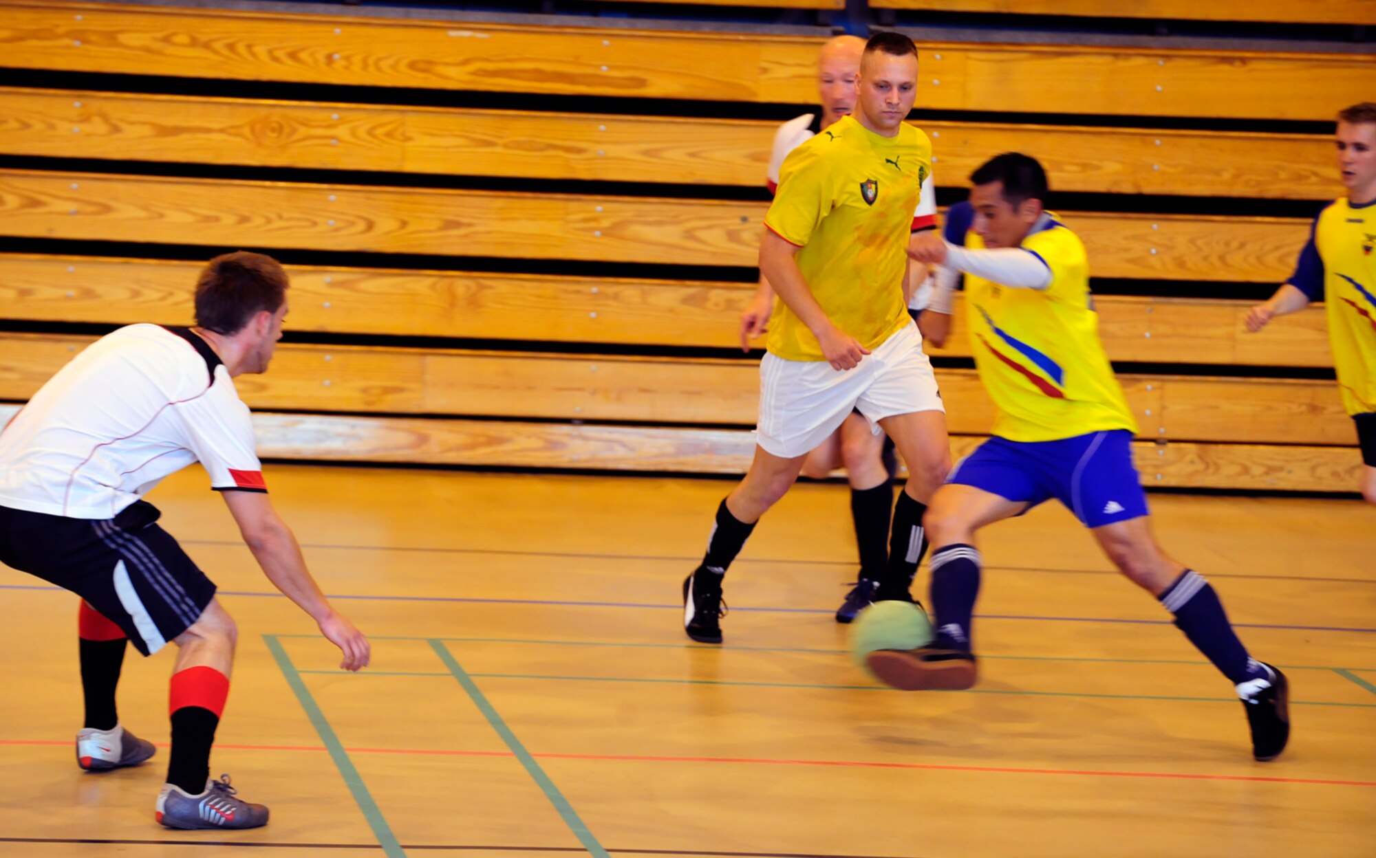 RAF MILDENHALL, England  -- Jhonatan Cardenas (with ball), runs on the attack for the 352nd Special Operations Group during the RAF Mildenhall Intramural Indoor Soccer Championship at the North Side Fitness Center, May 20, 2011. Cardenas scored the only goal for his team in an 8-1 defeat against the 100th Civil Engineer Squadron. (U.S. Air Force photo/Senior Airman Ethan Morgan)